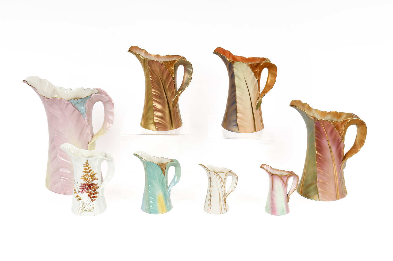 Group of Seven Royal Worcester Porcelain Leaf-Form Pitchers, Various Sizes: Description: Group of Seven Royal Worcester porcelain pitchers with gilt and enamel decorated palm leaves. Additional Royal Worcester items from the estate of Stuart Brown will be featured in our upco