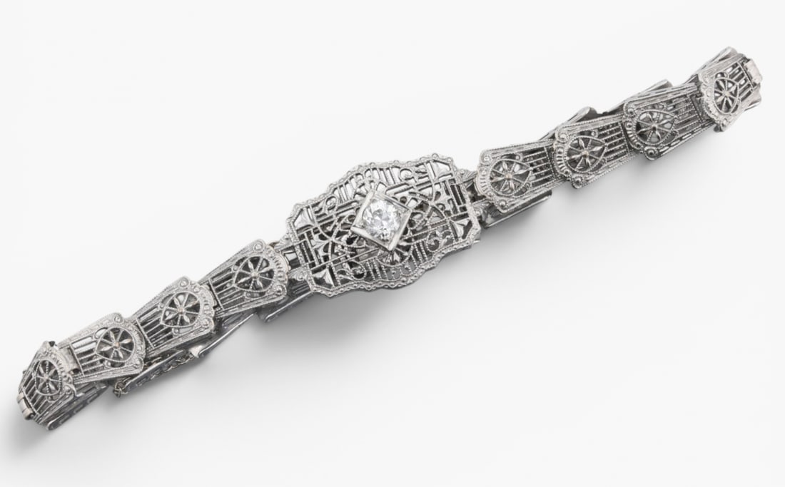 14 Karat White Gold Art Deco Diamond Bracelet: Description: A 14K White gold pierced filigree link Art Deco bracelet set with one 0.25 Ct. European-cut diamond. Markings & Inscriptions: 14K "BF" and maker's hallmark Date: 1920 Art Deco Maker: