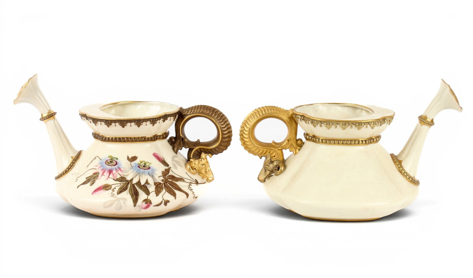 Two Royal Worcester Porcelain Watering Pots: Description: Two Royal Worcester porcelain watering pots. Both with gilt, scrolling handles terminating in a ram's head and gilt decoration t the spout and neck. One watering pot decorated with gilt a