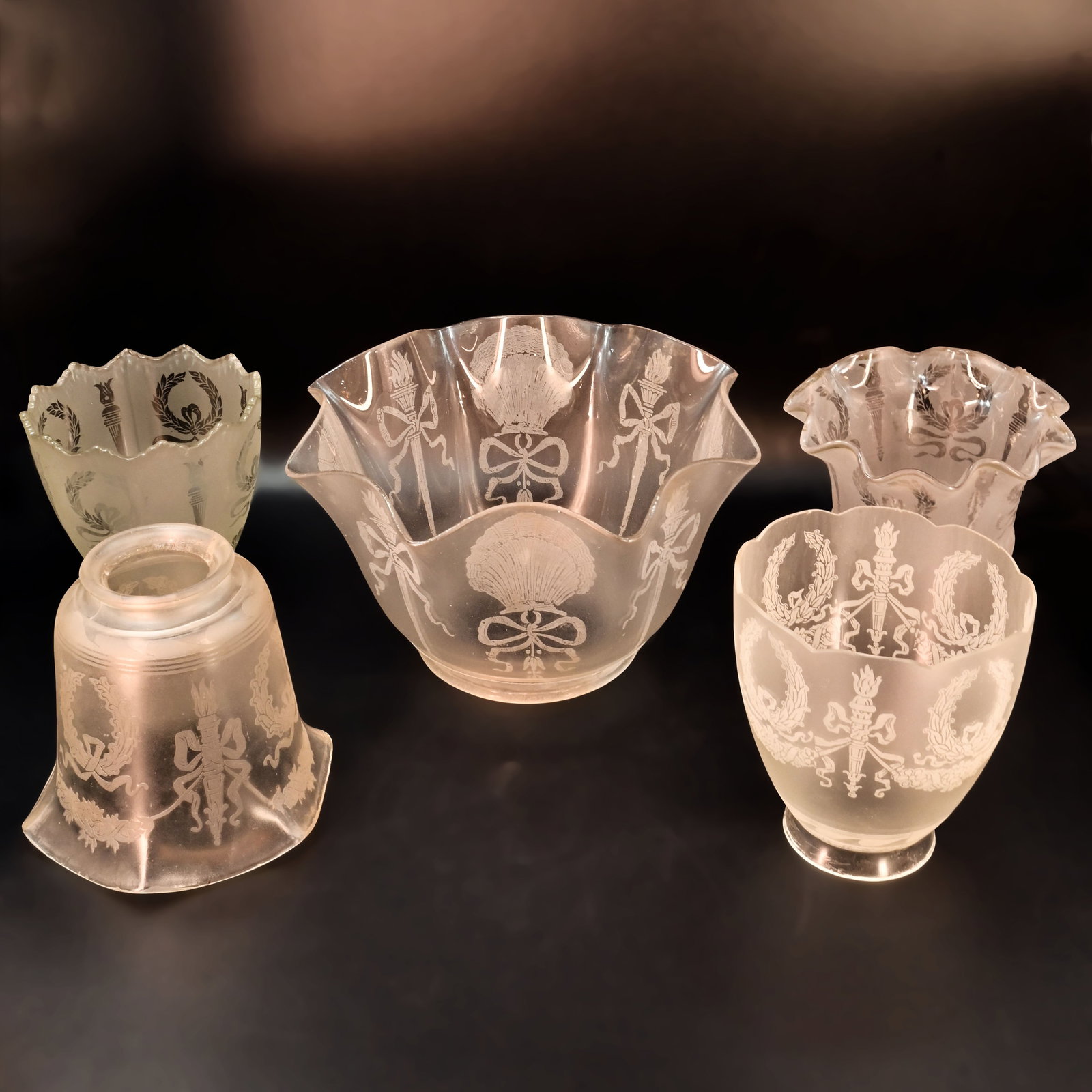 Group of four 2 1/4" fitter and one 4" fitter gas/electric etched glass shades with torch motif: Group of four 2 1/4" fitter and one 4" fitter gas/electric etched glass shades with torch motif. Back Left: 4" tall x 4 1/4" diameter. Front Left: 4 1/8" tall x 4 3/4" diameter. Center: 4 1/2" tall x