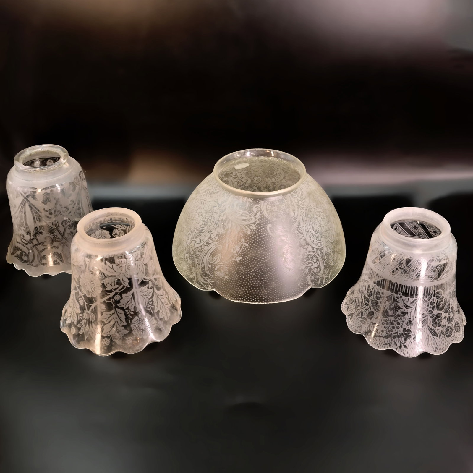 Group of three 2 1/4" fitter and one 4" fitter etched gas/electric glass shades: Group of three 2 1/4" fitter and one 4" fitter etched gas/electric glass shades. Back Left: 4 1/2" tall x 4 1/2" diameter. Front Left: 4" tall x 4 1/2" diameter. Back Right: 4" tall x 7 1/2" diameter.