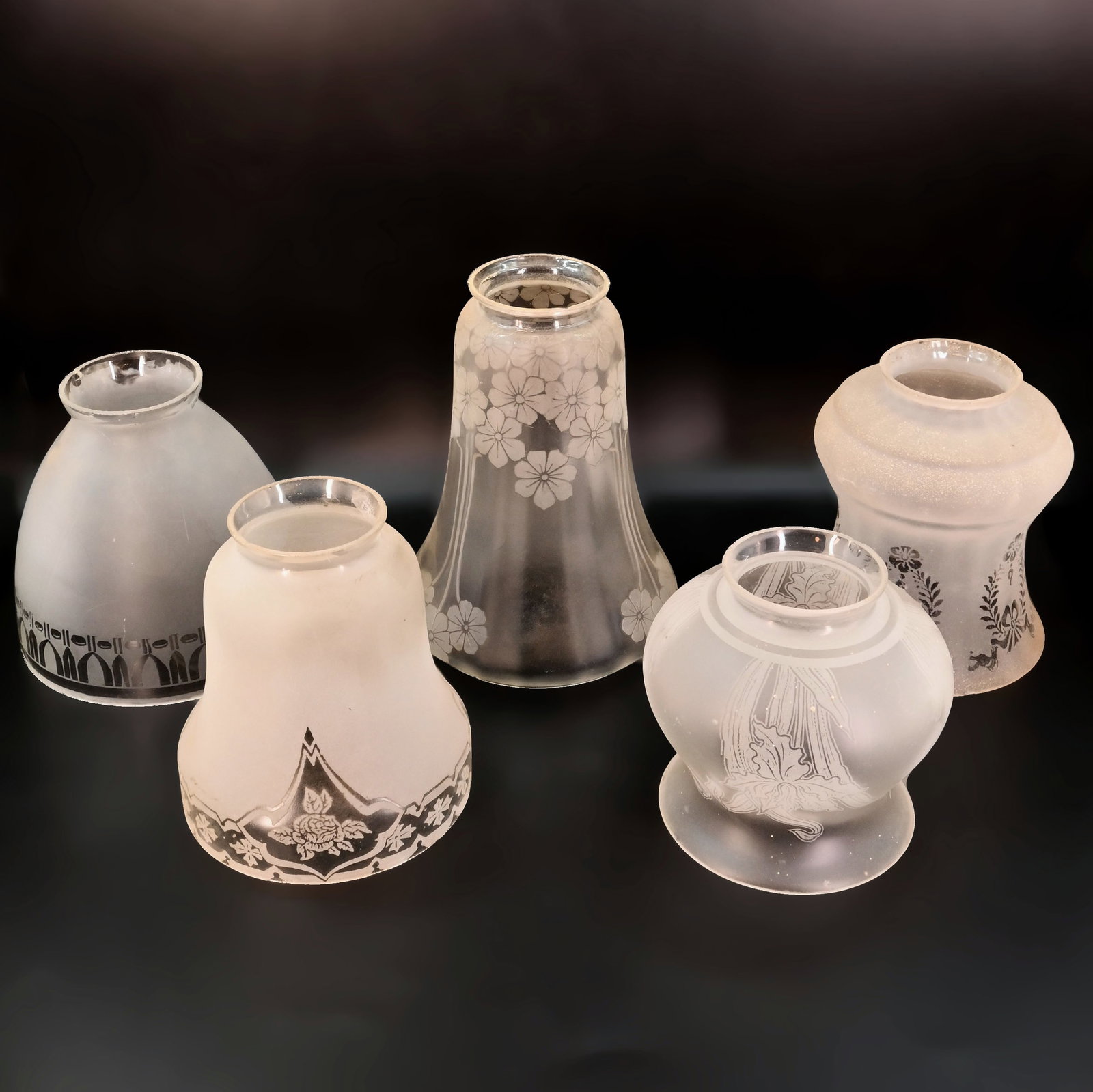 Group of four 2 1/4" fitter distinctive mixed design painted/etched frosted glass shades: Group of four 2 1/4" fitter distinctive mixed design painted/etched frosted glass shades. Back Left: 4 1/2" tall x 5" diameter. Front Left: 4 1/2" tall x 4 1/4" diameter. Center: 6 1/2" tall x 4 3/4" 