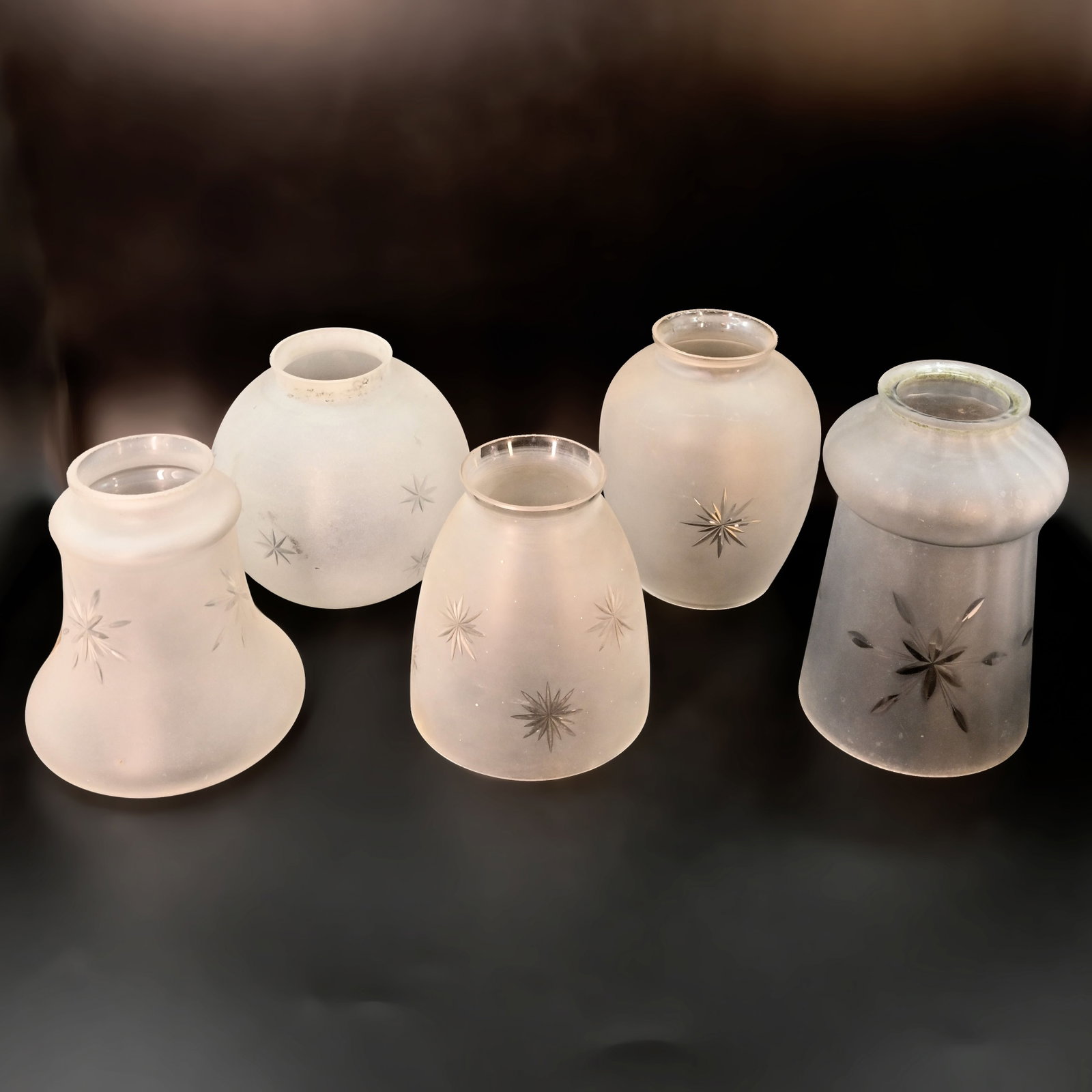 Group of five 2 1/4" fitter star etched mixed design glass shades: Group of five 2 1/4" fitter star etched mixed design glass shades. Front Left: 4 3/4" tall x 4 1/2" diameter. Back Left: 4 1/4" tall x 4 1/2" diameter. Center: 4 1/4" tall x 4" diameter. Back Right: 4
