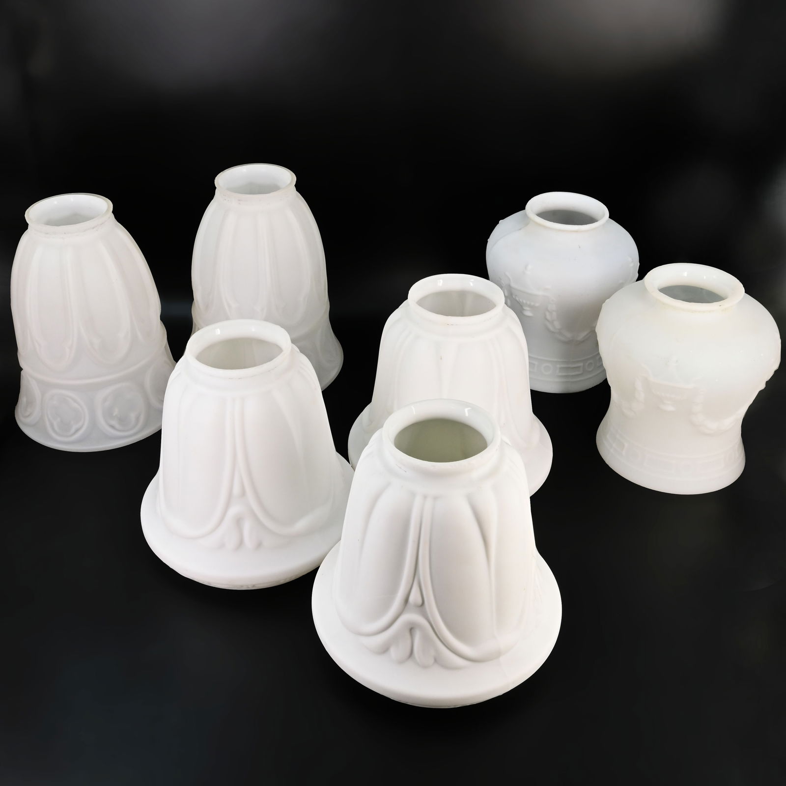 Group of seven 2 1/4" fitter white glass shades, two pairs and one trio matching: Group of seven 2 1/4" fitter white glass shades, two pairs and one trio matching. Left back pair: 6" tall x 4 3/4" diameter. Front Cener Trio: 4 3/4" tall x 5" diameter. Right Back pair: 5" tall x 4"