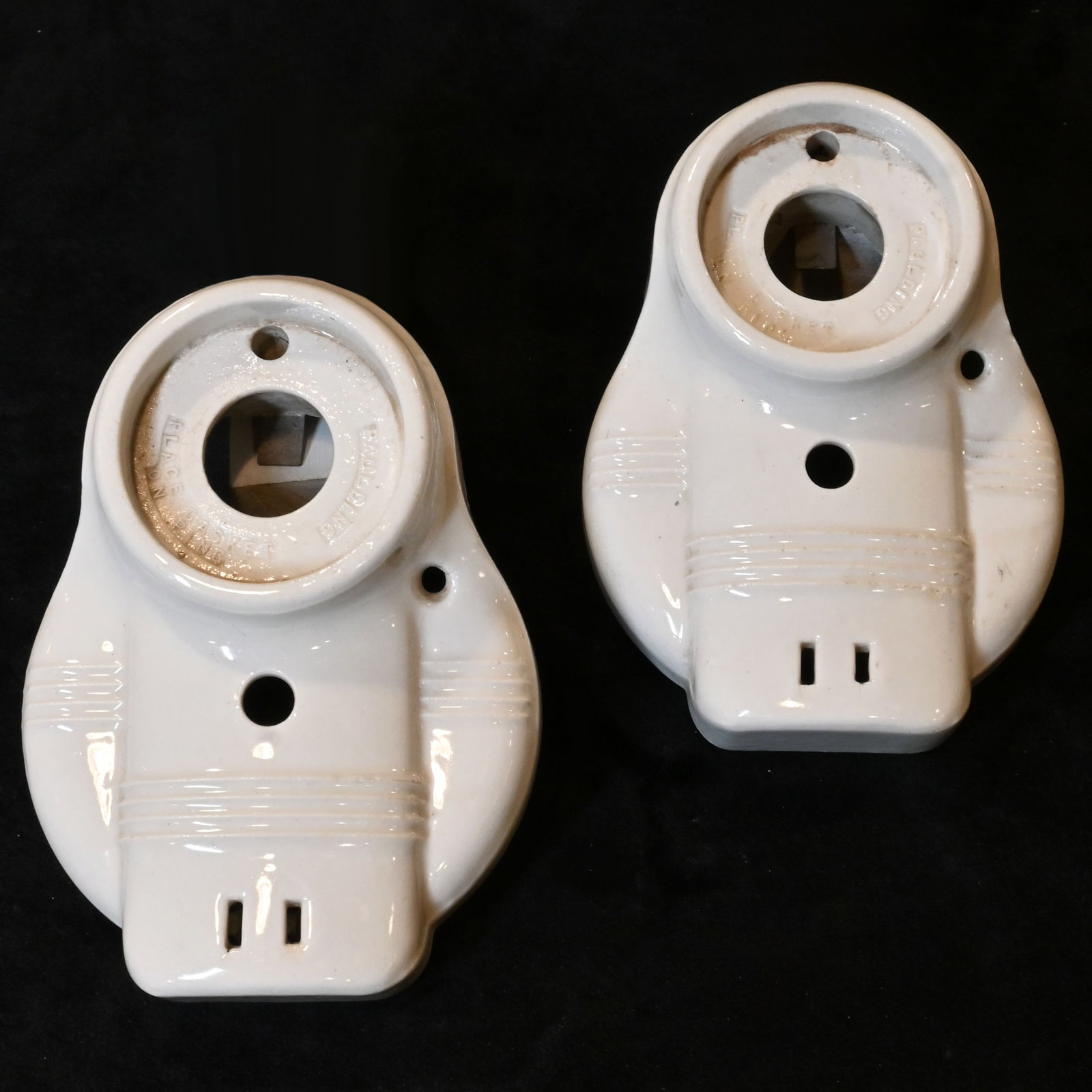 Pair of white porcelain bathroom sconces by Paulding: Pair of white porcelain bathroom sconces by Paulding. 2 1/4" opening for shade. Shadeis held on by socket ring. 6.25" tall x 4. 625" widex 2" projection. This item is offered with no reserve.