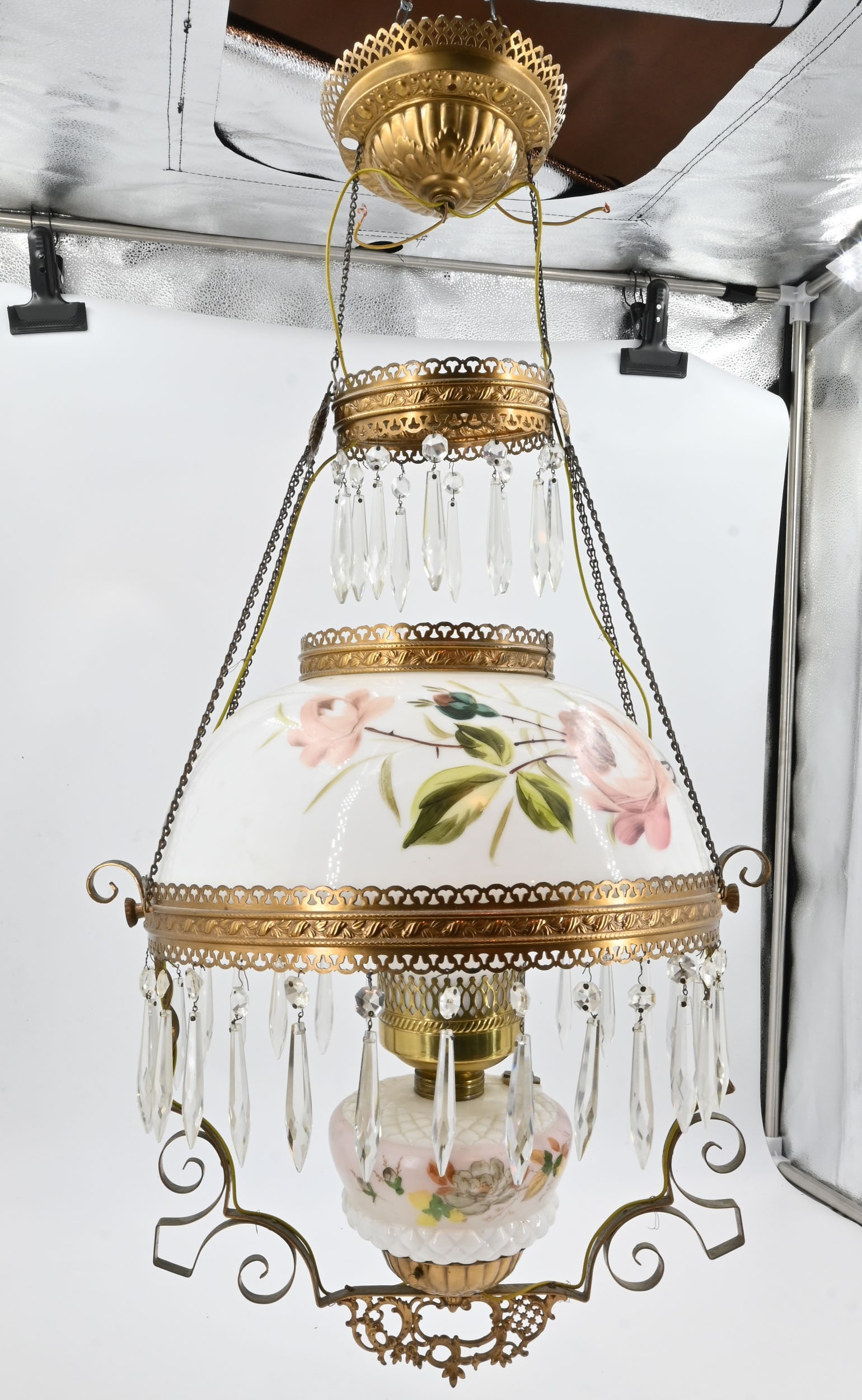 Converted oil/kerosene hanging lamp with handpainted roses: Converted oil/kerosene hanging lamp with handpainted roses. Dimensions: 33" total height x 16" diameter. Material: Brass and hand painted white milkglass with clear and frosted chimney. One medium Edi