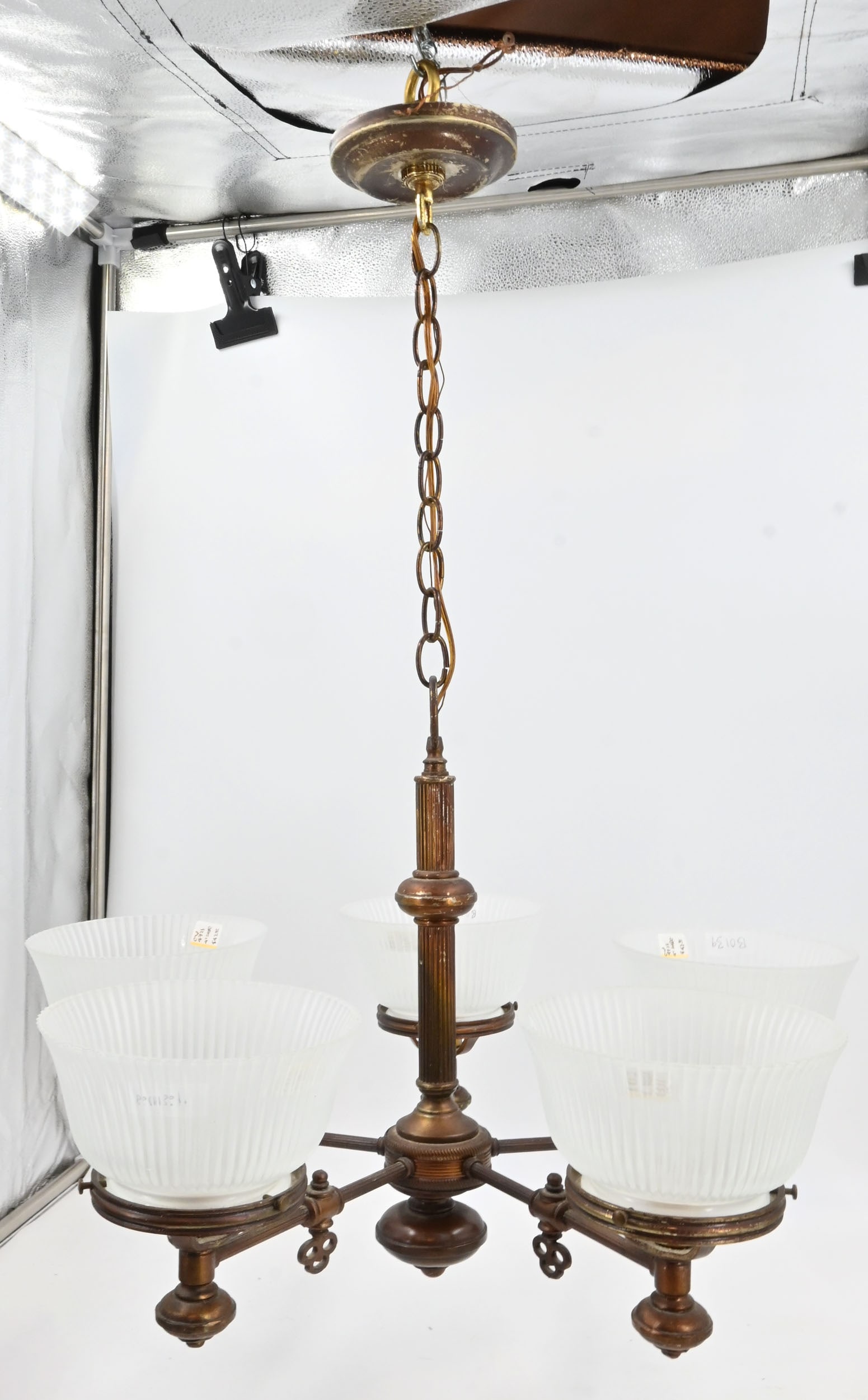 Five arm chandelier with fluted arms and 4" fitter fluted shades: Five arm chandelier with fluted arms and 4" fitter fluted shades. Brass and iron. Set of five fluted frosted gas/electric shades. 4" fitters. Shades are 7" wide x 3 3/4" tall. Fixture body without sha