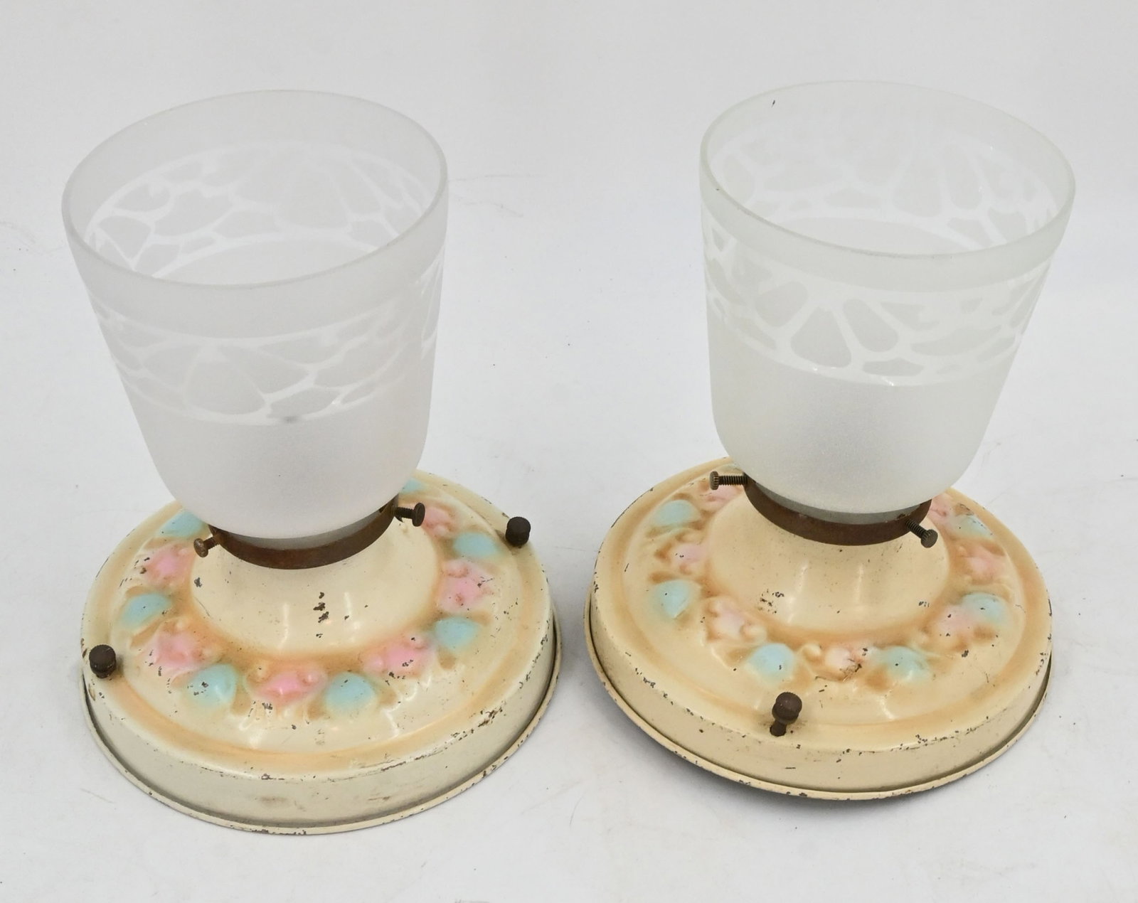 Pair of matching stamped steel polychrome flushmounts with frosted patterned shades: Pair of matching stamped steel polychrome flushmounts with frosted patterned shades. One medium edison socket per fixture. 2.25" fitters. Dimensions with shades: 7.25" tall x 6.5" diameter. Shades are