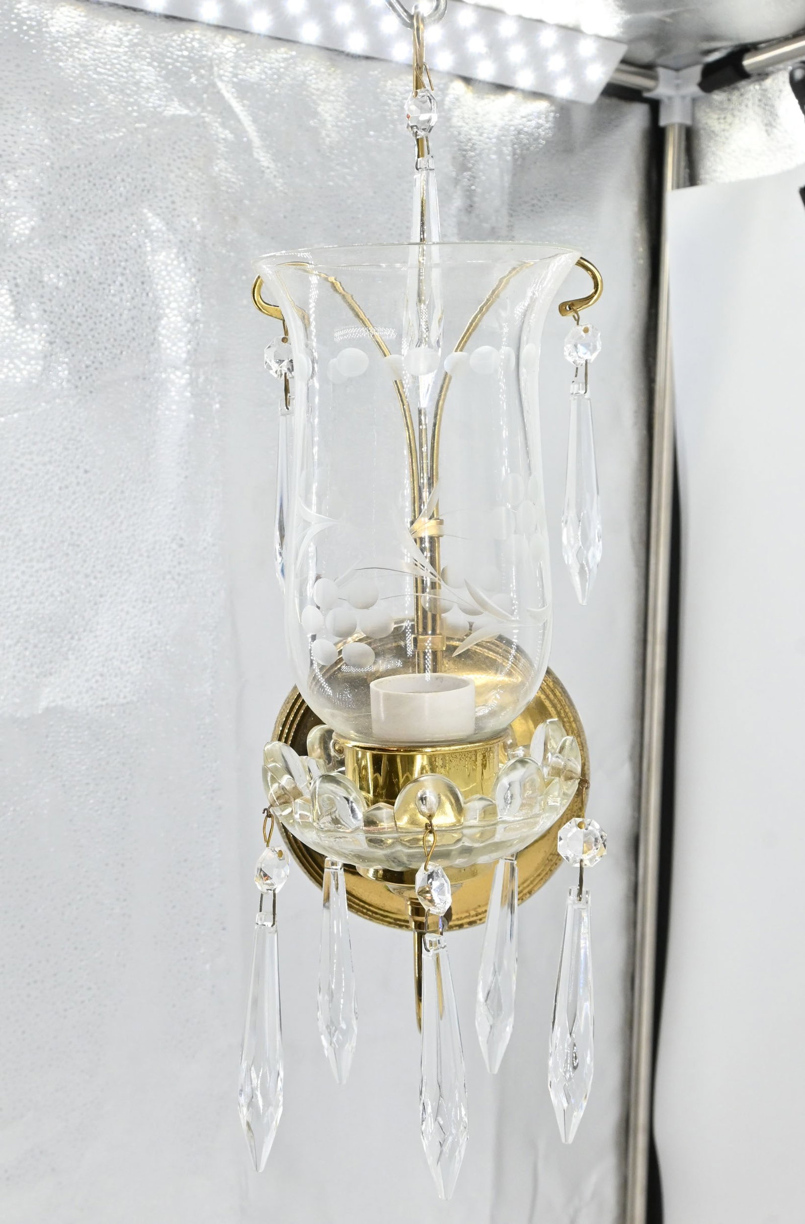 Single candle brass and crystal sconce with etched chimney: Single candle brass and crystal sconce with etched chimney. One medium Edison socket. 13.5" tall x 4.75" wide x 6.5" projection. This item is offered with no reserve.