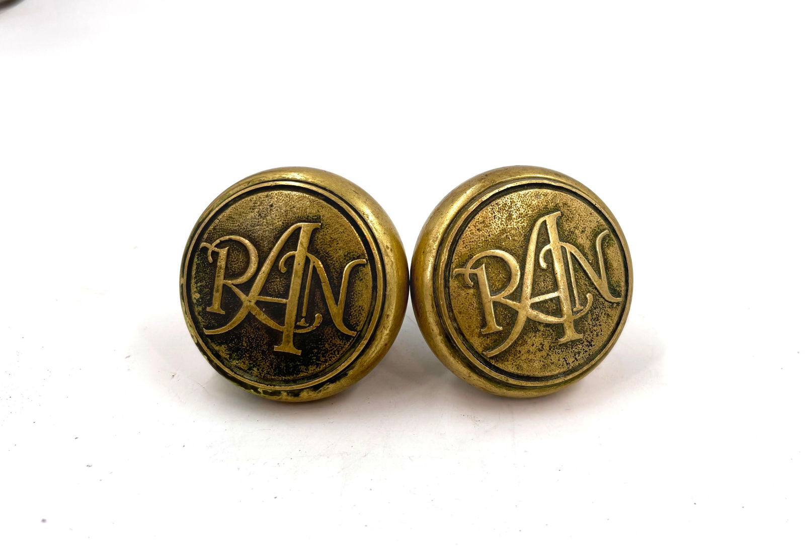 Pair of cast brass doorknobs with RAN initials (1 of 4)