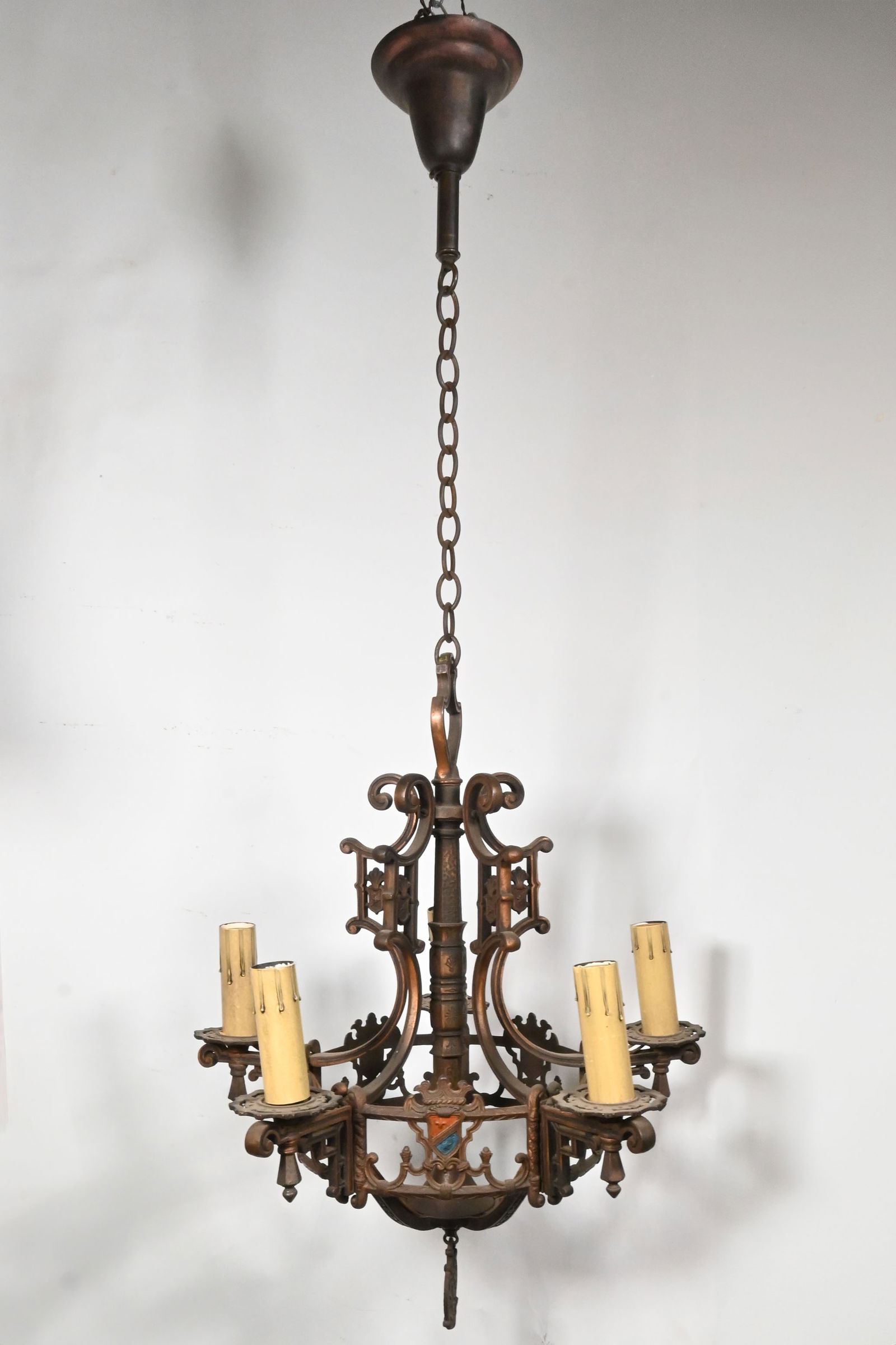 Five arm cast iron polychrome tudor chandelier: Five arm cast iron polychrome tudor chandelier. Condition: Age Consistent. Finish: Original. Illumination: 5 medium Edison sockets. Dimensions: Total hanging length: 43 inch. Diameter: 19 inch. Body a
