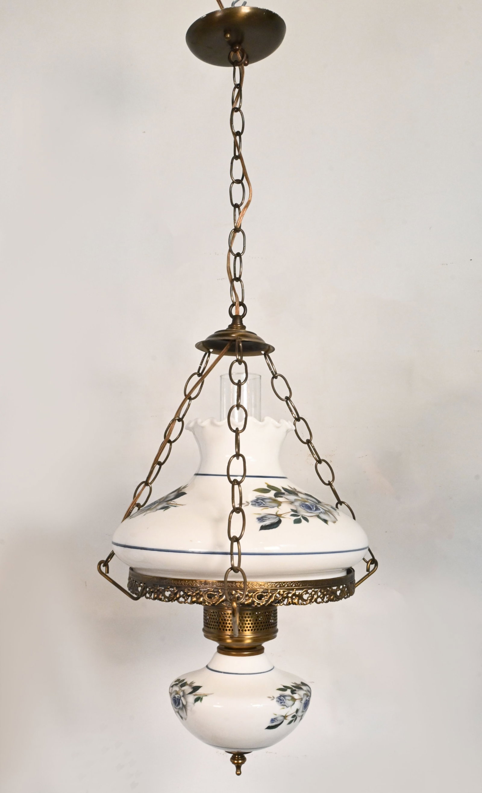 Blue floral converted victorian oil/kerosene lamp pendant: Blue floral converted victorian oil/kerosene lamp pendant. Material: Brass plated steel and brass, stenciled milkglass. One medium Edison socket. Dimensions: 34 inch total length x 15 inch diameter. M
