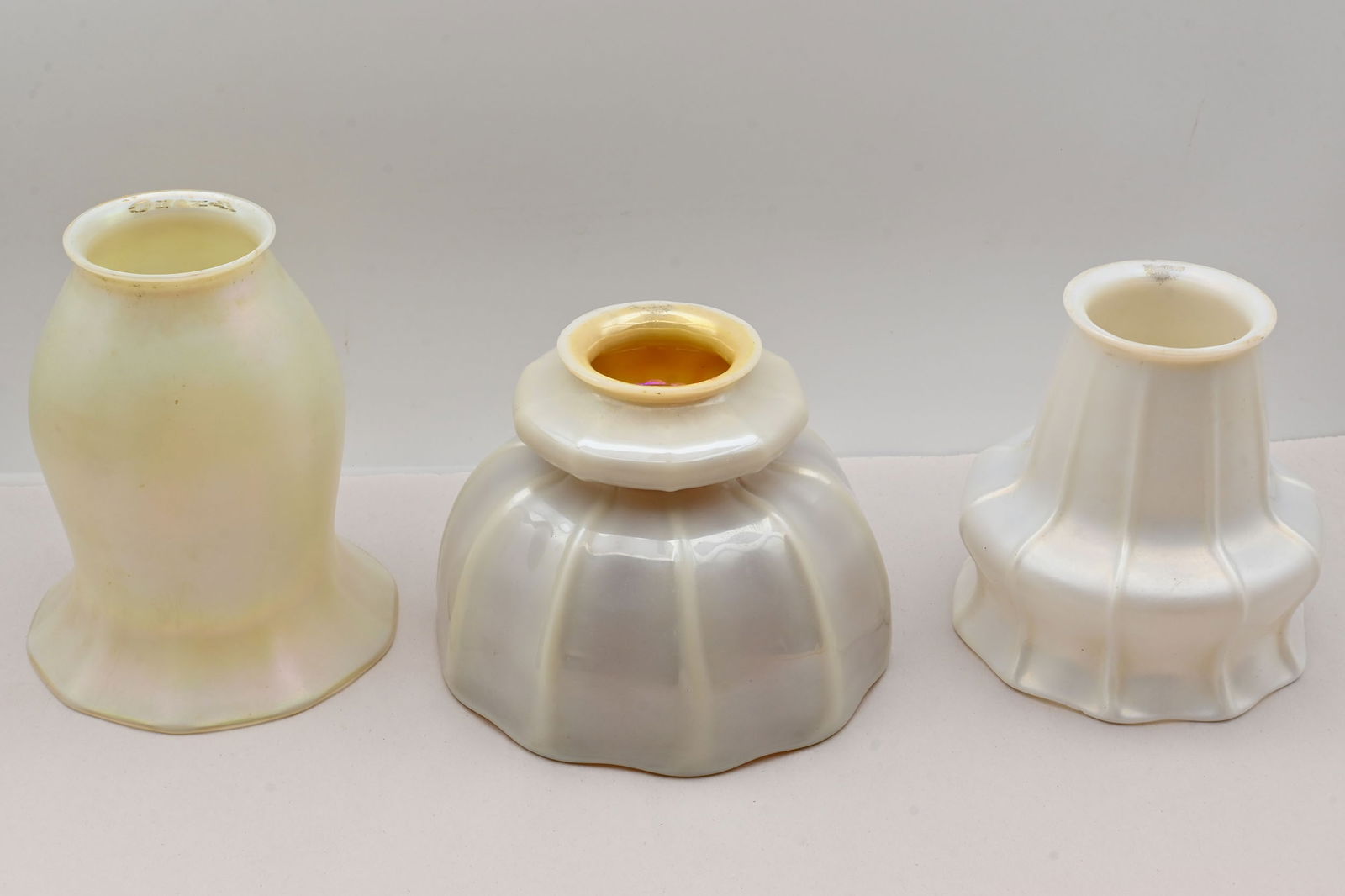 Set of three calcite art glass shades, Steuben and Quezal: Set of three calcite art glass shades, Steuben and Quezal. Condition: Age Consistent. Left: Quezal calcite shade is 5 inches tall x 4.25 inches diameter. Middle: Steuben with aurene interior is 4 inch