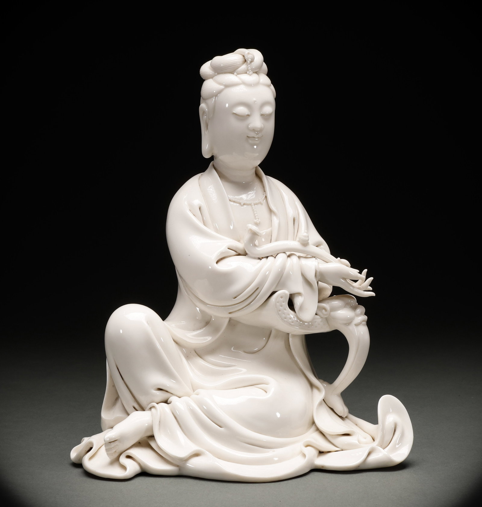 Ming Dynasty Dehua Kiln Guanyin Statue: Ming Dynasty Dehua kiln Guanyin statue, fine body, warm glaze color, dignified statue, compassionate face, fluent robe lines, exquisite craftsmanship. Height: 27cm, Width: 22cm, Weight: 1711g. A fine 