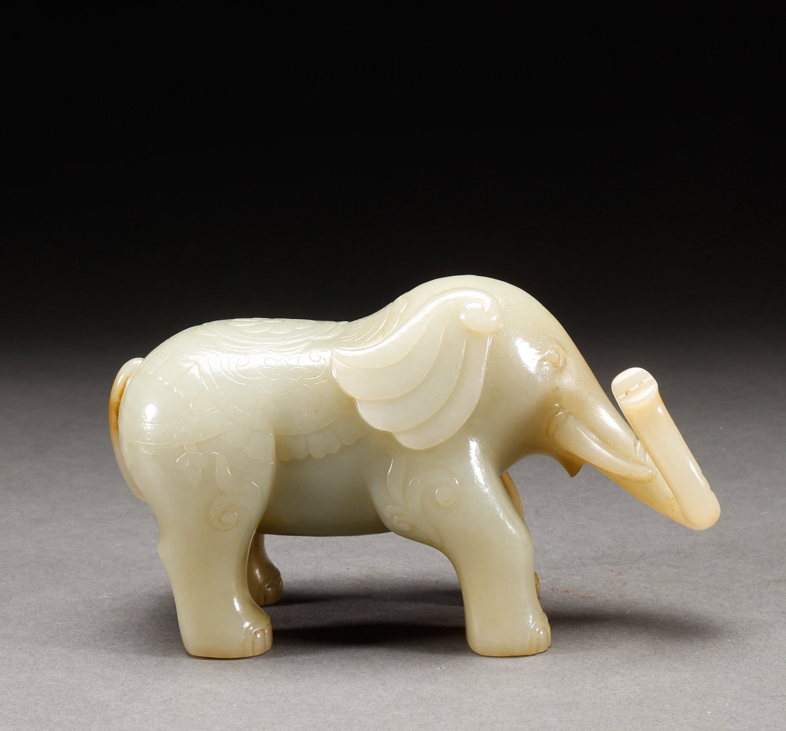 Qing Dynasty Hetian Blue White Jade Elephant Ornament: Greenish-white jade elephant ornament, warm and fine jade texture, elephant with plump body, trunk curled holding ruyi, symbolizing peace and prosperity. Height: 10cm, Width: 16cm, Weight: 1076g.