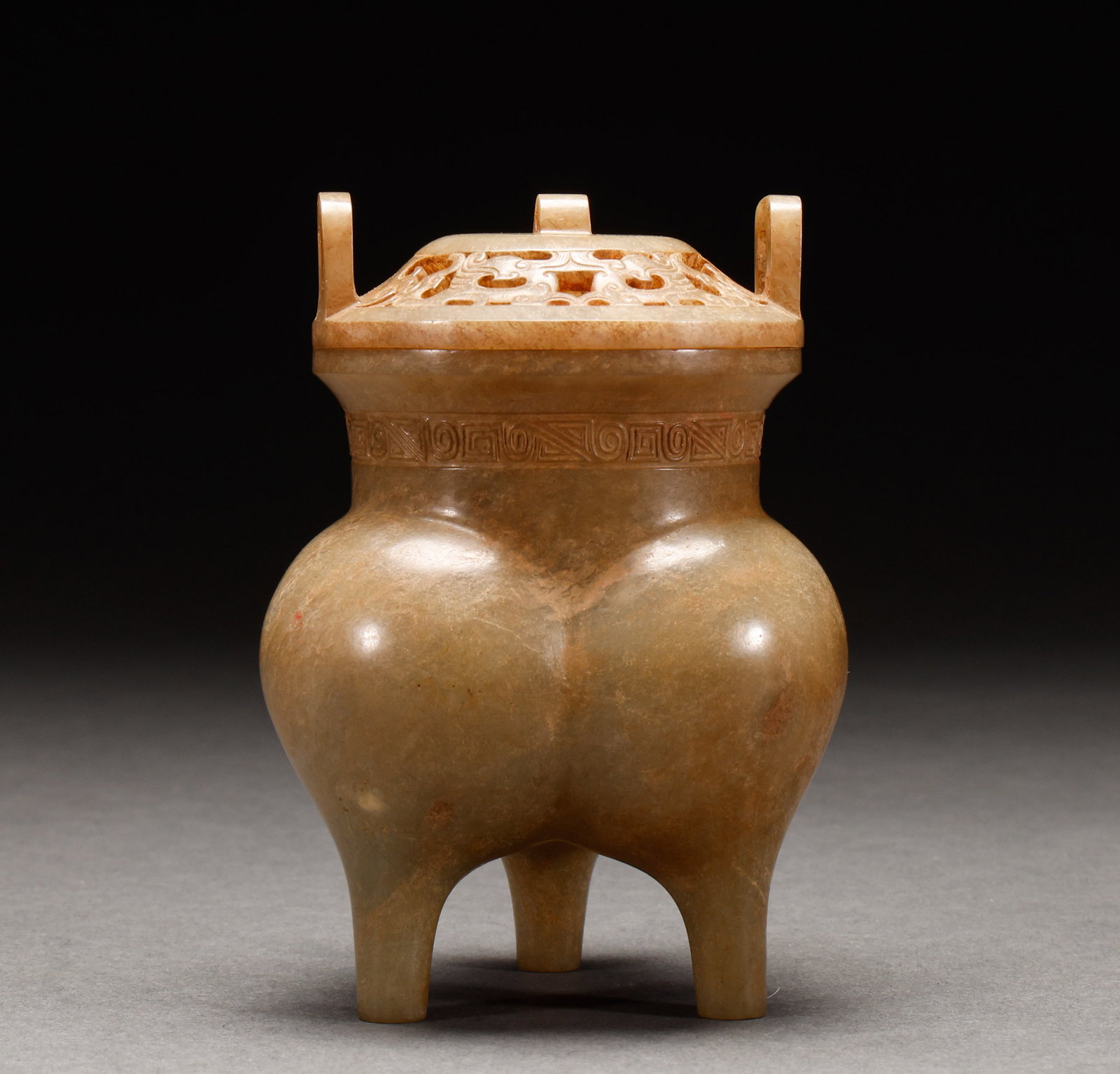 Before the Ming Dynasty, Hotan Jade was exposed to the three legged tripod style fumigation furnace: Weathered jade tripod li-form incense burner, weathered jade, li-form burner body with three legs, openwork carving on cover, key-fret pattern on neck. Height: 11.5cm, Width: 8cm, Weight: 305g.