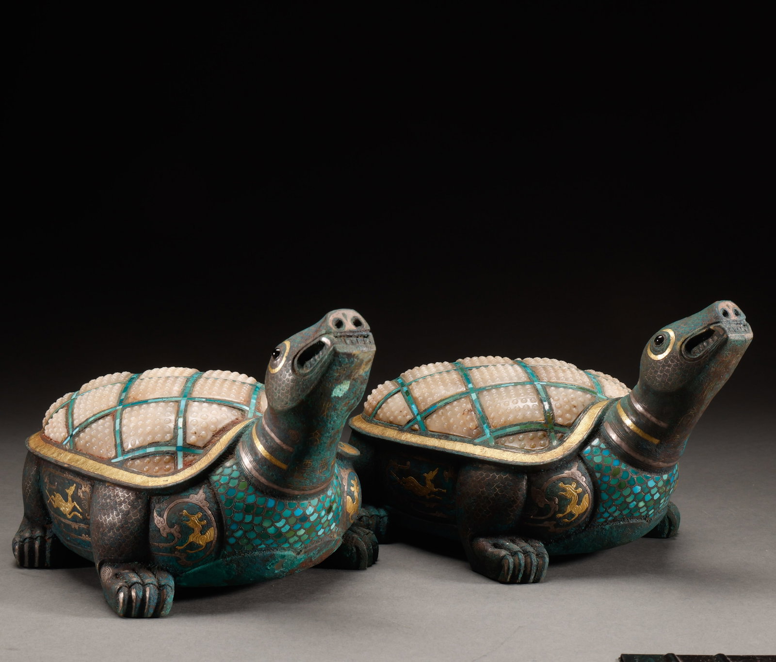 Before the Ming Dynasty, there was a pair of turtles with copper, gold, silver, and inlaid jade: A pair of turtle-form metal ornaments with long upturned necks, pale segmented shells and turquoise-coloured inlay. Gilt-coloured roundels and geometric bands decorate the darker bodies, with rubbing 