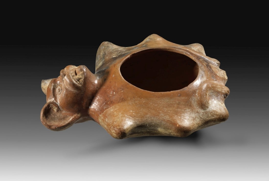 Fledermaus.: Bat. Moche, around AD 500 - 700. Length 20,5cm. Reddish clay painted in red and beige. Low bowl in bat shape, with handle masterfully shaped as head. With TL-Test! Small missing fragment of the tail, 