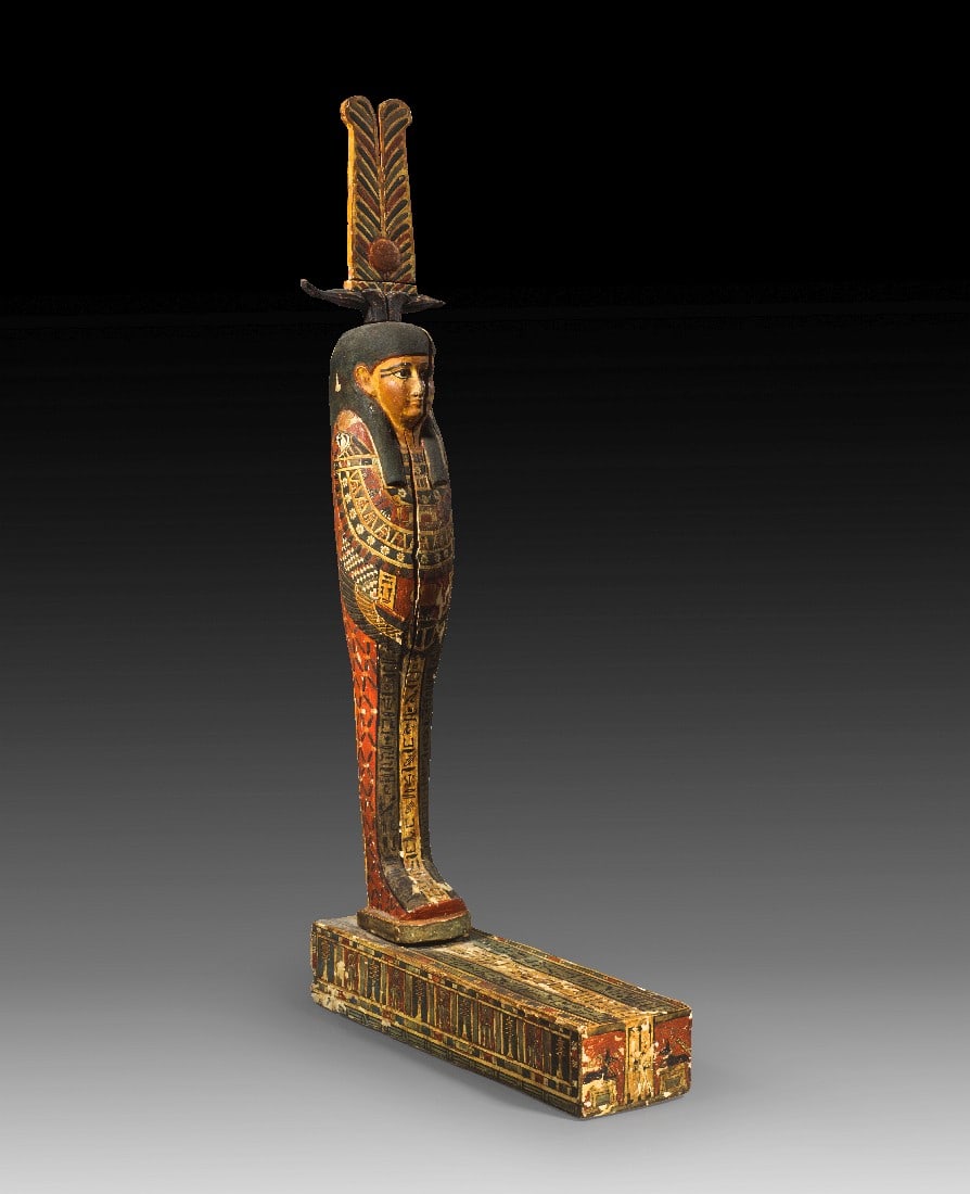 Große Figur des Ptah-Sokar-Osiris mit Basis.: Große Figur des Ptah-Sokar-Osiris mit Basis. Spätzeit, 1. Jt. v. Chr. H Figur 71,5cm, Basis L 38,5cm, B 11cm, H 8cm. Holz mit verschiedenfarbiger Bemalung auf Stuck. Die Figur steht auf einer