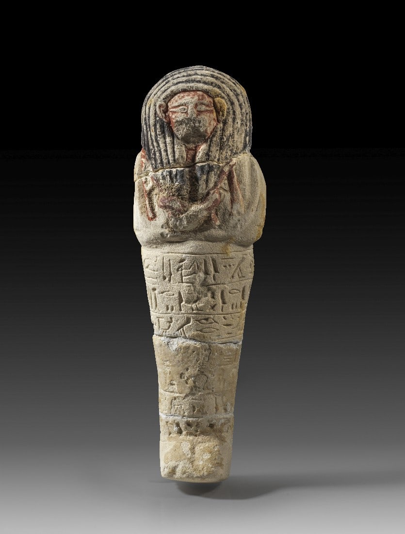 Großes Uschebti des Any.: Großes Uschebti des Any. Neues Reich, Ramessidisch, 19. - 20. Dynastie, 1292 - 1070 v. Chr. H 29cm, H mit Holzsockel 19cm. Kalkstein mit Resten der Bemalung. Mumienförmig mit Perücke, Bart sowie