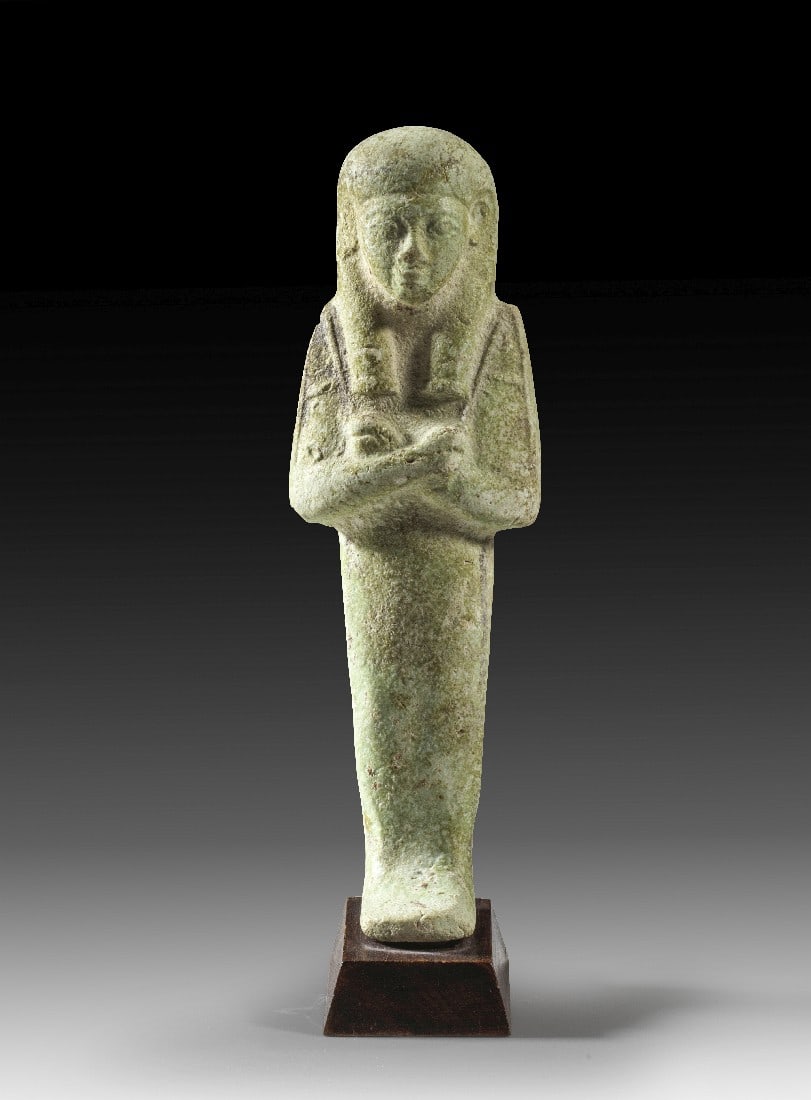 Türkises Uschebti.: Türkises Uschebti. Spätzeit, 26. - 30. Dynastie - Ptolemäerzeit., 664 - 30 v. Chr. H ohne Sockel 12,5cm, mit Sockel 13,8cm. Türkise Fayence. Mumienförmige Figur mit dreigeteilter Perücke und