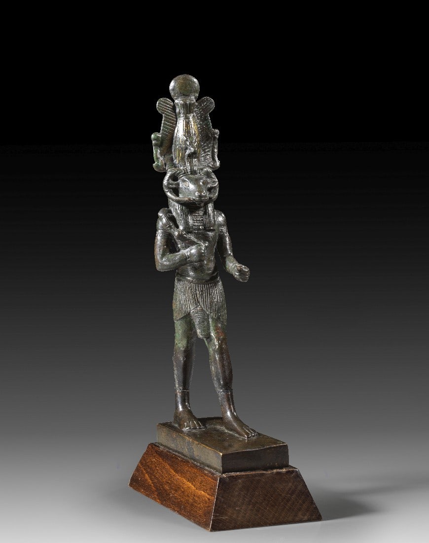 Große Statuette des Chnum.: Große Statuette des Chnum. 3. Zwischenzeit bis Spätzeit, ca. 1070 - 664 v. Chr. H 22cm, mit Holzsockel 25cm. Bronzevollguss mit Resten der Vergoldung. Große Figur des stehenden, widderköpfigen