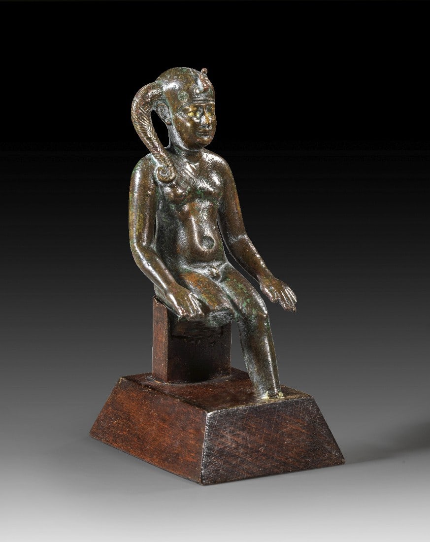 Statuette des Harpokrates.: Statuette des Harpokrates. Spätzeit, 26. - 27. Dynastie, ca. 664 - 404 v. Chr. H 9,5cm, mit Sockel 11,5cm. Bronzevollguss, Augen vergoldet. Sitzender, nackter Knabe, dessen Arme seitlich der Beine