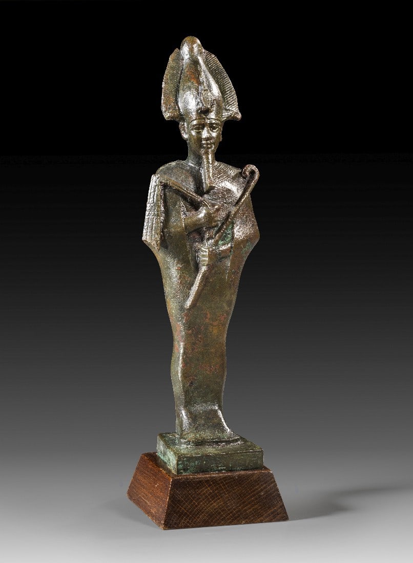 Bronzestatuette des Osiris.: Bronzestatuette des Osiris. 3. Zwischenzeit bis Spätzeit, ca. 1070 - 664 v. Chr. H 22,8cm, mit Holzsockel 25cm. Bronzevollguss. Auf der leicht trapezförmigen, angegossenen Basis auf drei Seiten