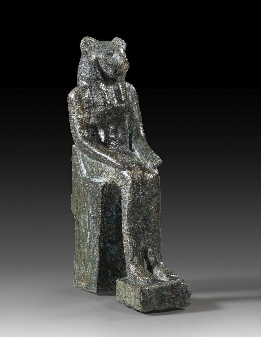 Bronzestatuette der Sachmet.: Bronzestatuette der Sachmet. Spätzeit, 1. Jt. v. Chr. H 13cm. Bronzehohlguss. Thronende, löwenköpfige Göttin Sachmet, bekleidet mit einem eng anliegenden Gewand. Beide Hände liegen auf den