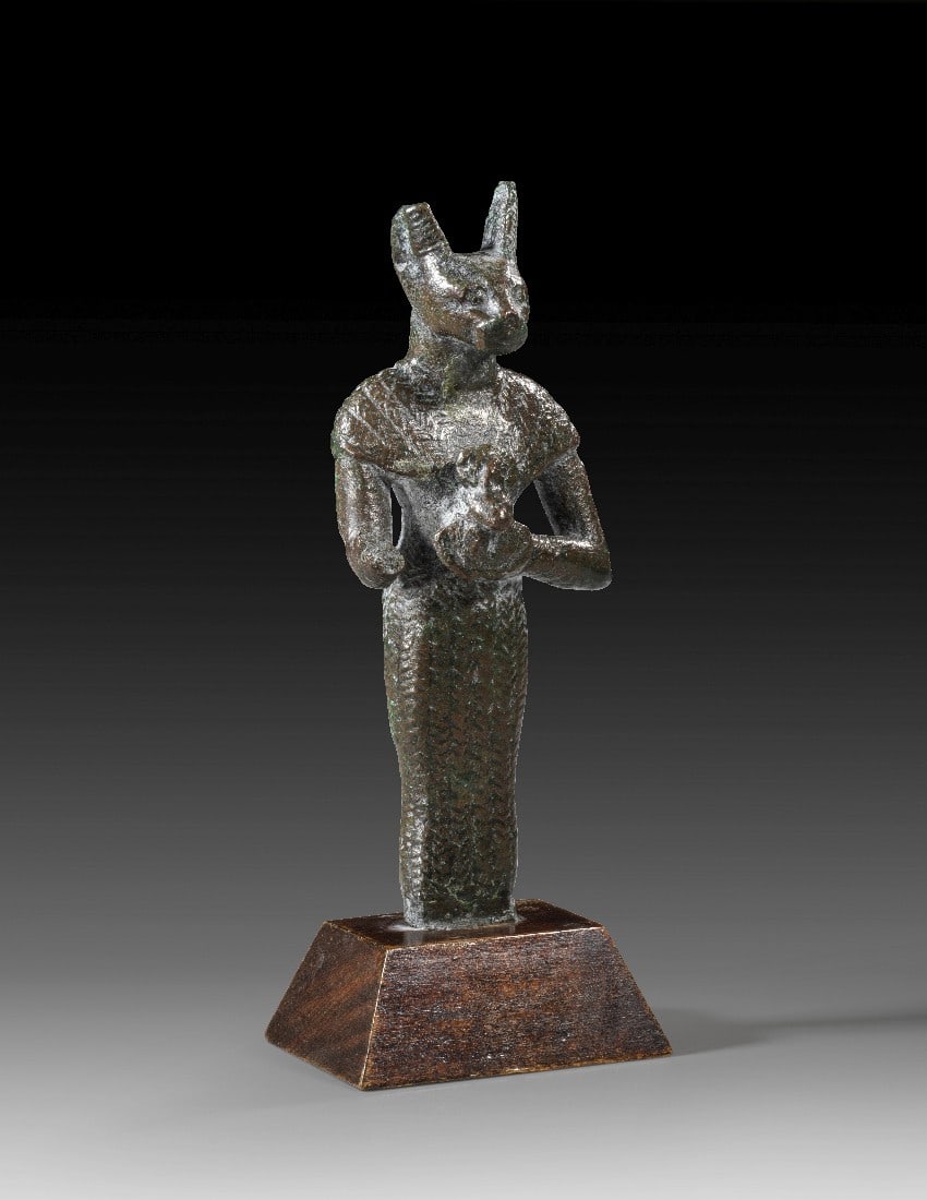 Statuette der Bastet.: Statuette der Bastet. Spätzeit, 26. - 27. Dynastie, ca. 664 - 404 v. Chr. H 10,3cm, mit Sockel 12,3cm. Bronzevollguss. Stehende Bastet in Menschengestalt mit Katzenkopf. Sie trägt ein eng