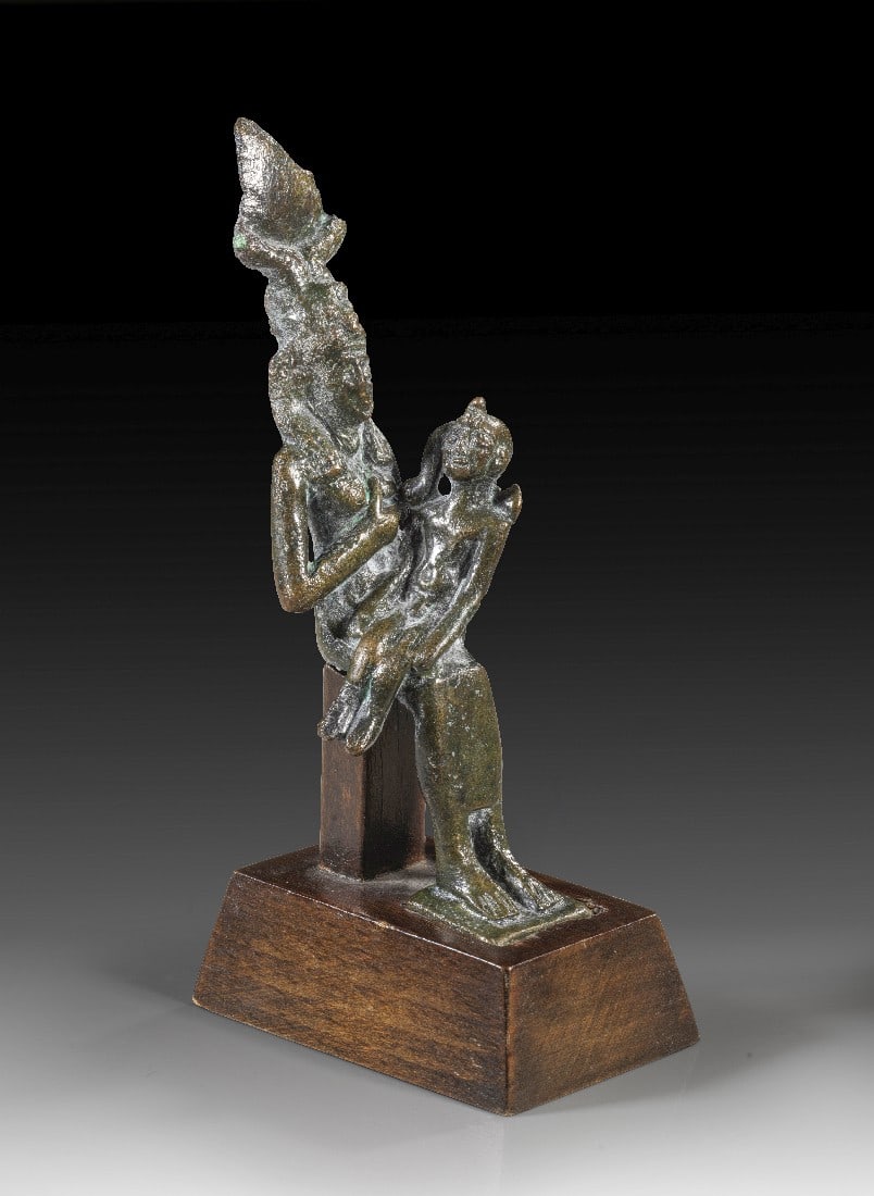 Statuette der Isis Lactans.: Statuette der Isis Lactans. Spätzeit, 26. - 27. Dynastie, ca. 664 - 404 v. Chr. H 10,5cm, mit Sockel 12cm. Bronzevollguss. Sitzende Isis, die dem Horusknaben auf ihrem Schoss die linke Brust gibt.