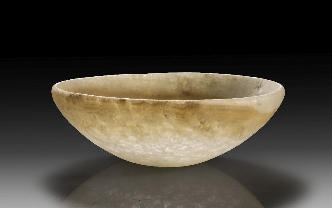 Alabasterschale.: Alabasterschale. 3. Jt. v. Chr. H 6,1cm, ø 18,6cm. Bis auf eine leicht bräunliche Maserung unter dem Rand aus weißem, tatsächlich durchscheinendem Alabaster. Halbkugelige Schale mit leicht