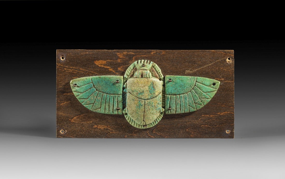 Geflügelter Skarabäus.: Geflügelter Skarabäus. Spätzeit, ca. 664 - 332 v. Chr. B 14cm, L 6,5cm. Hellgrüne Fayence. Binnenzeichnung geritzt. Zwei winzige Sprünge, montiert auf eine Holzplatte. Provenienz: Ex Slg. Dr.