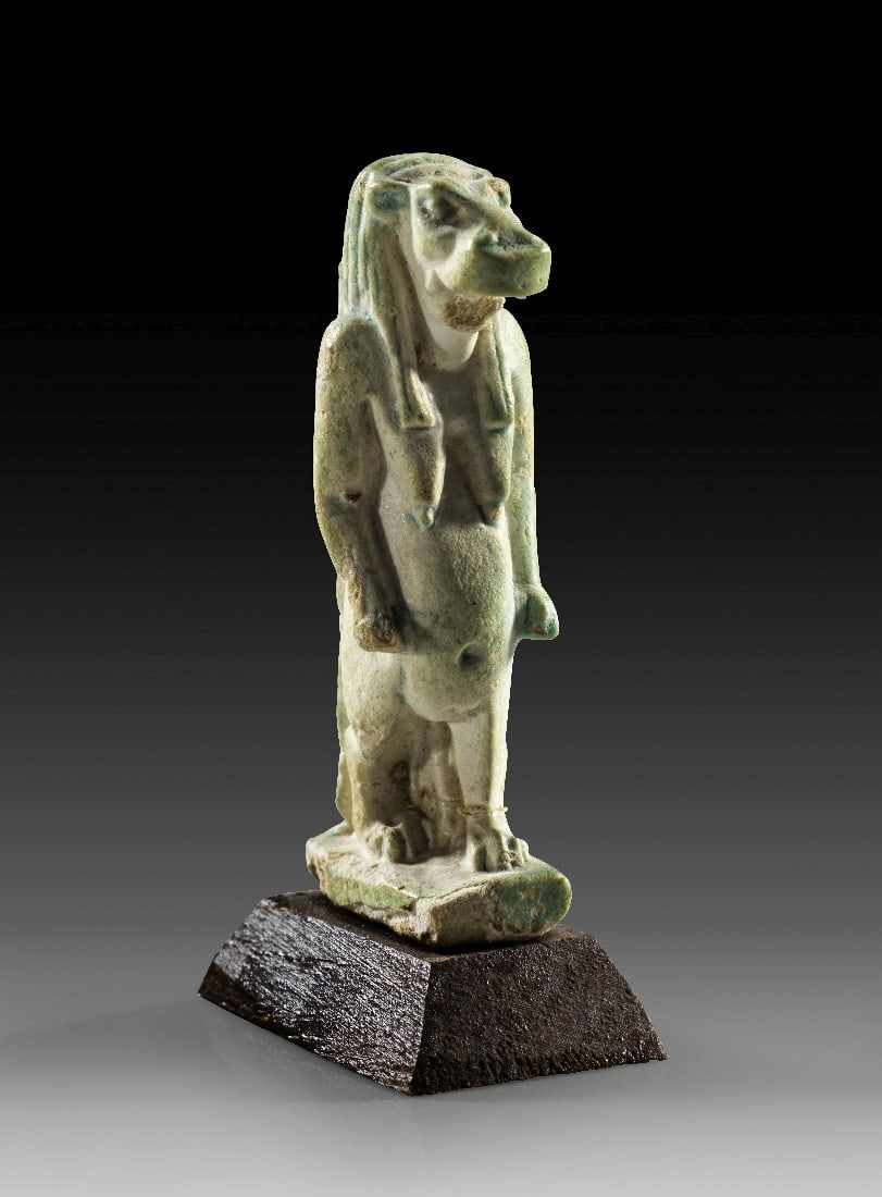 Thoeris-Amulett.: Thoeris-Amulett. Spätzeit, 1. Jt. v. Chr. H 4cm (ohne Sockel). Fayence. Statuette der nilpferdgestaltigen Göttin Thoeris, im Nacken Öse. Unterkiefer abgebrochen, auf Holzsockel. Provenienz: Ex