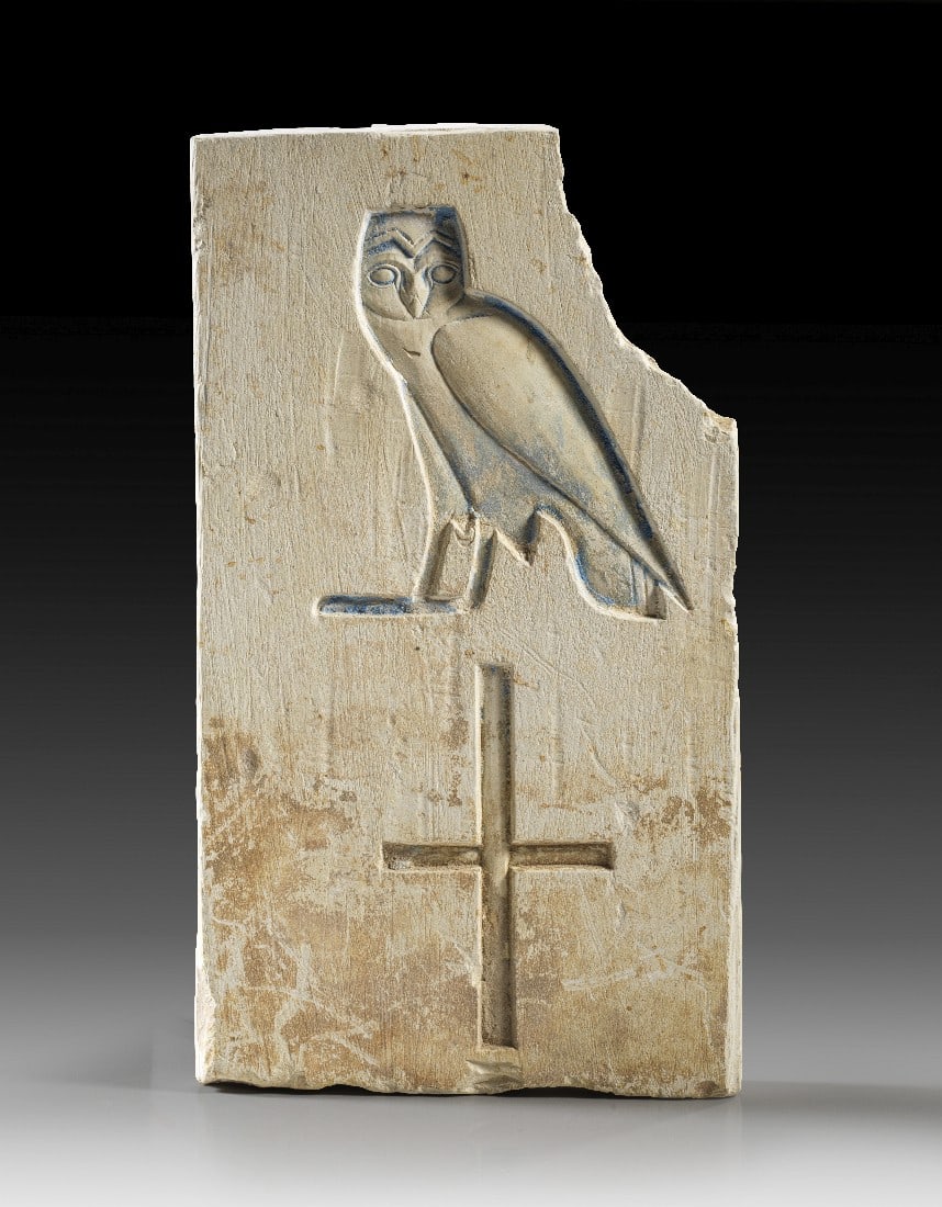 Inschriftenfragment.: Inschriftenfragment. Spätzeit, Ptolemäisch(?). H 20,5cm, B 12cm, D 7cm. Fragment einer Kalksteinplatte. Auf der Vorderseite zwei Hieroglyphen: Ein Falke und darunter ein Kreuz. Der Falke mit Resten
