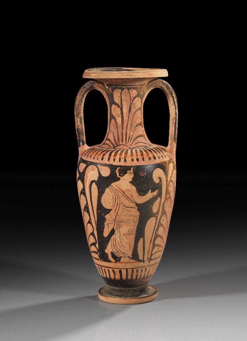 Elegante kampanische rotfigurige Halsamphora aus der Werkstatt des Libation-Malers.: Elegante kampanische rotfigurige Halsamphora aus der Werkstatt des Libation-Malers. Um 350 v. Chr. H 30,7cm, ø 13,4cm. Auf der einen Seite eine junge Frau lässig an einen Pfeiler gelehnt und einen