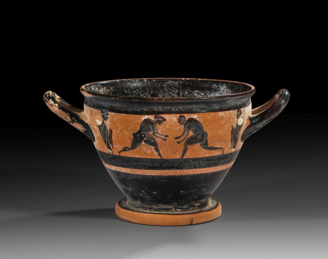 Großer attischer schwarzfiguriger Skyphos der CHC-Gruppe.: Großer attischer schwarzfiguriger Skyphos der CHC-Gruppe. 500 - 490 v. Chr. H 11,5cm, B mit Henkeln 21,7cm, ø Mündung 15,6cm. Beidseitig je ein Ringerpaar zwischen zwei Trainern. Details in Weiß