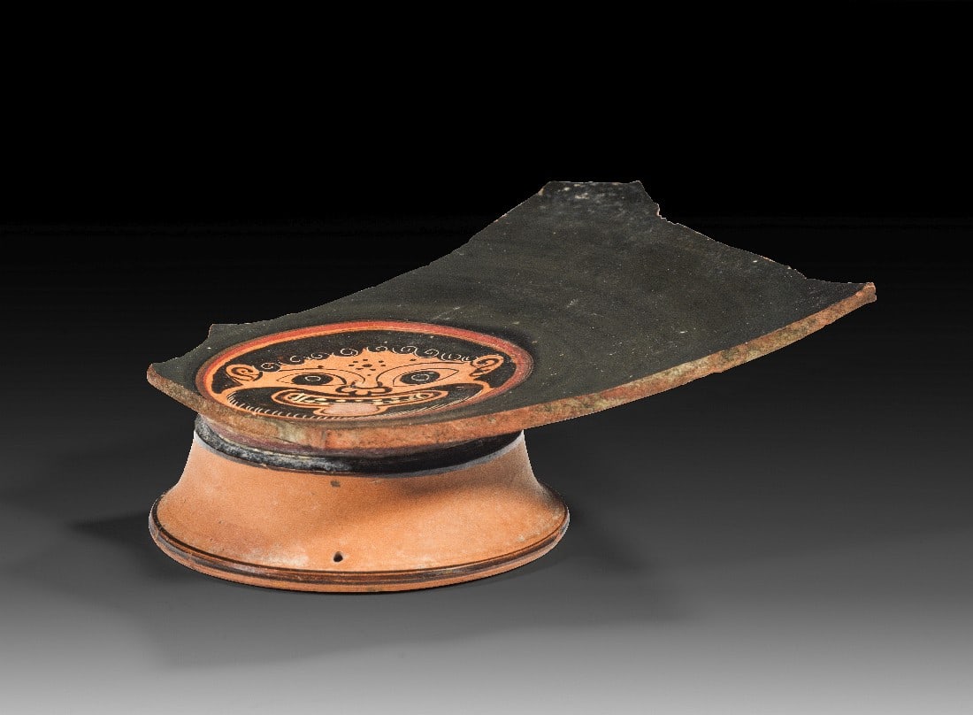 Fragment mit Fuß einer attischen schwarzfigurigen Schale aus der Werkstatt des Nikosthenes.: Fragment mit Fuß einer attischen schwarzfigurigen Schale aus der Werkstatt des Nikosthenes. 530 - 520 v. Chr. H erhalten 6cm, B 17,1cm. Chalkidisierende Schale mit dem charakteristischen konischen,