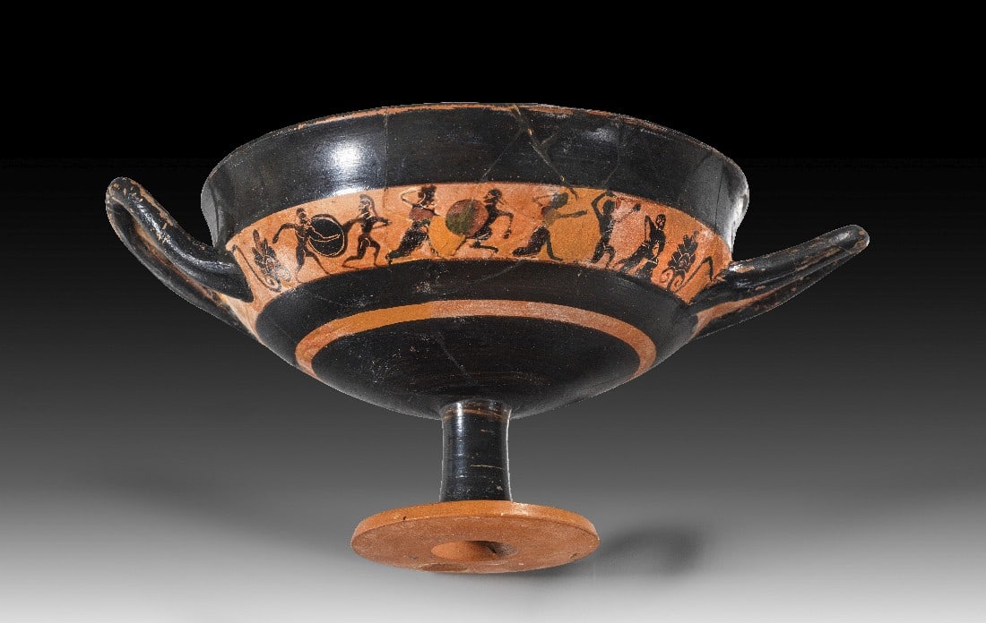 Kleine attische schwarzfigurige Kleinmeisterschale.: Kleine attische schwarzfigurige Kleinmeisterschale. Um 540 v. Chr. H 10,1cm, B mit Henkeln 21cm, ø Becken 15,1cm. Bandschale mit tongrundigem Figurenfries unter dem abgesetzten Rand. Auf dem Fries