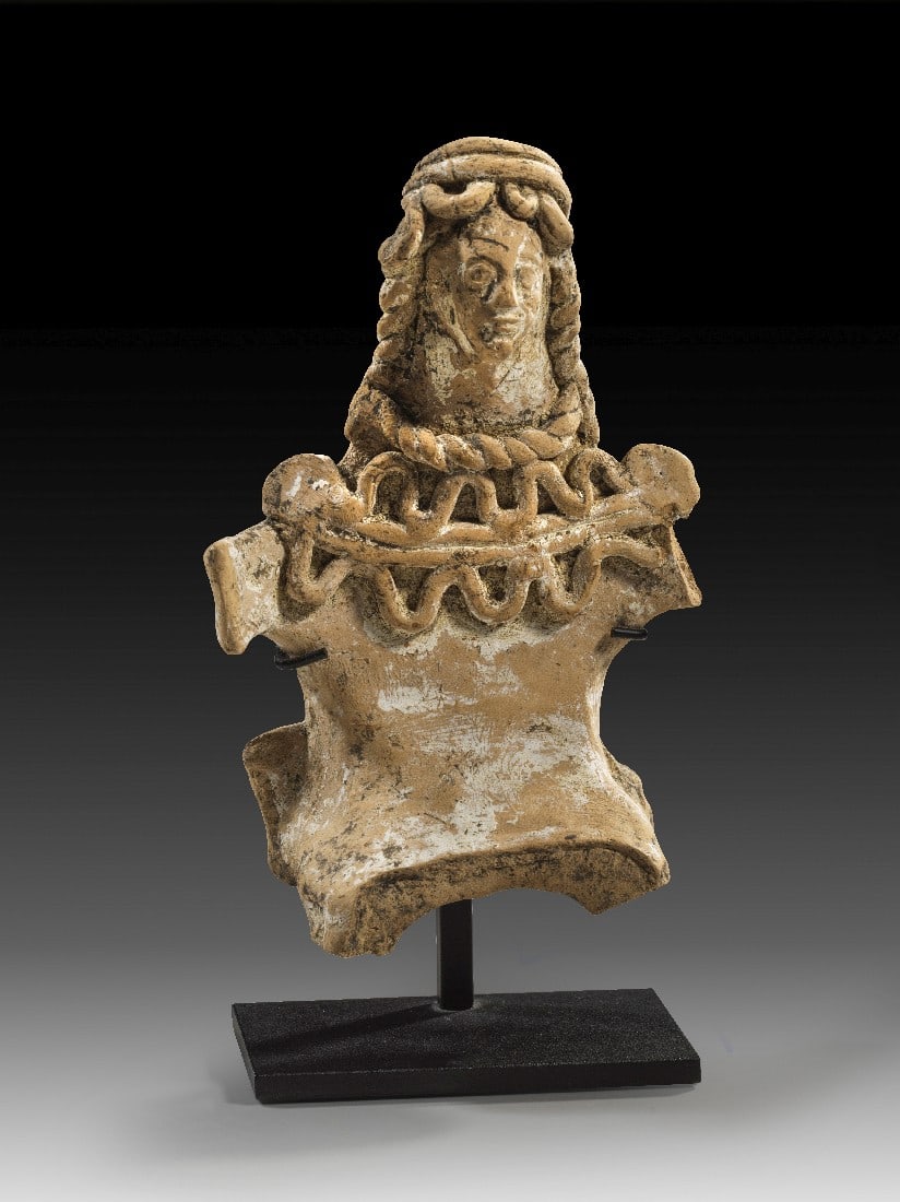 Griechisches Brettidol einer thronenden Schlangengöttin.: Griechisches Brettidol einer thronenden Schlangengöttin. Böotien, 2. Hälfte 6. Jh. v. Chr. H 14,5cm und mit Ständer 16,5cm. Hellbraune Terrakotta mit Resten weißer Engobe. Handgeformte Statuette