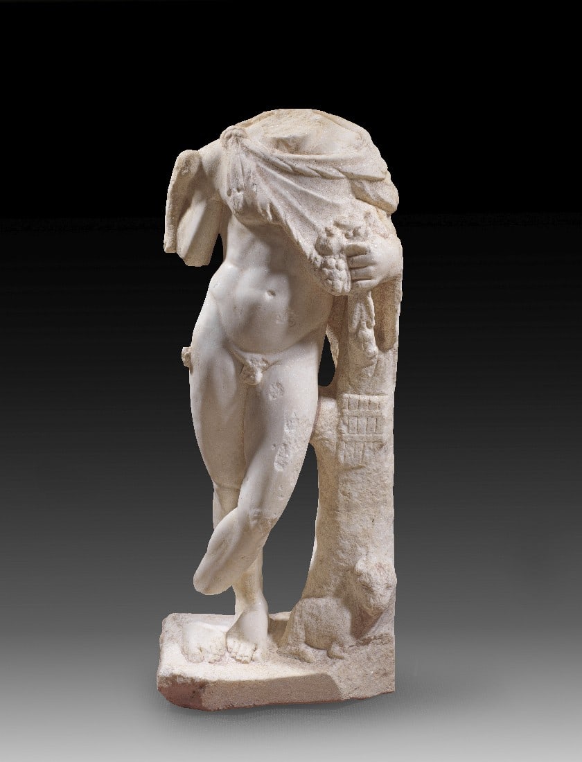 Satyr mit Fruchtschurz.: Satyr mit Fruchtschurz. Römische Kaiserzeit, 2. Jh. n. Chr. H 68cm. Weißer, feinkristalliner Marmor. Der Gefolgsmann des Dionysos ist von knabenhafter Statur. Er trägt nur ein über der rechten