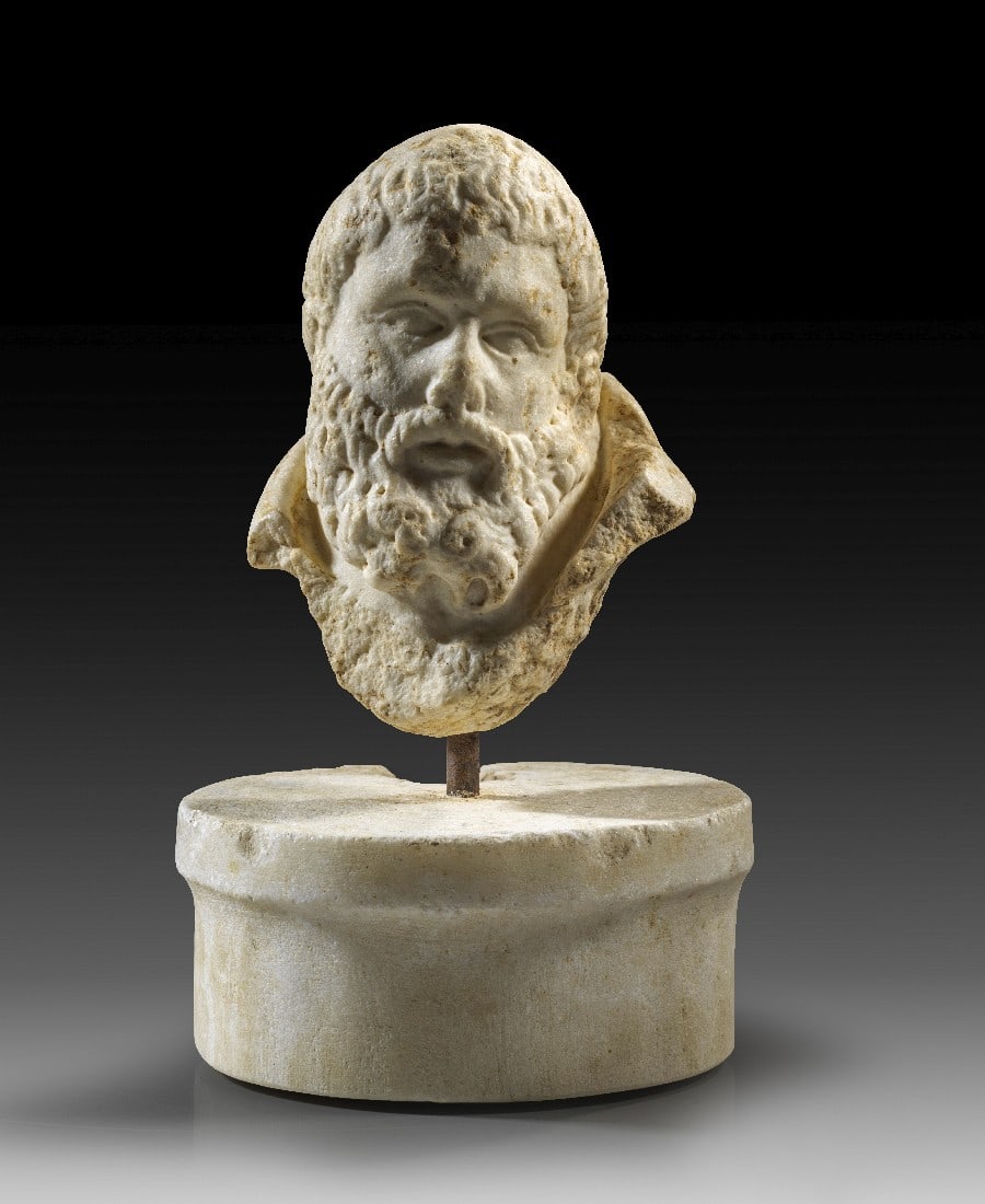 Büste des bärtigen Herakles.: Büste des bärtigen Herakles. Römische Kaiserzeit, 1. Jh. n. Chr. H ohne Basis 15cm. Weißer, feinkristalliner Marmor. Unterlebensgroße Einsatzbüste mit dem Kopf des bärtigen, älteren Herakles,