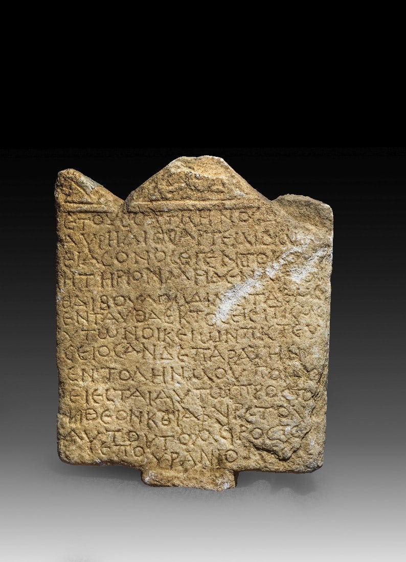 Grabstele mit Giebel und griechischer Inschrift.: Grabstele mit Giebel und griechischer Inschrift. Römisch, östliches Mittelmeergebiet, wohl 252 - 253 n. Chr. H 43cm, B unten 43cm, T max. 5cm. Weißer Marmor. Platte, die von einem Spitzgiebel mit