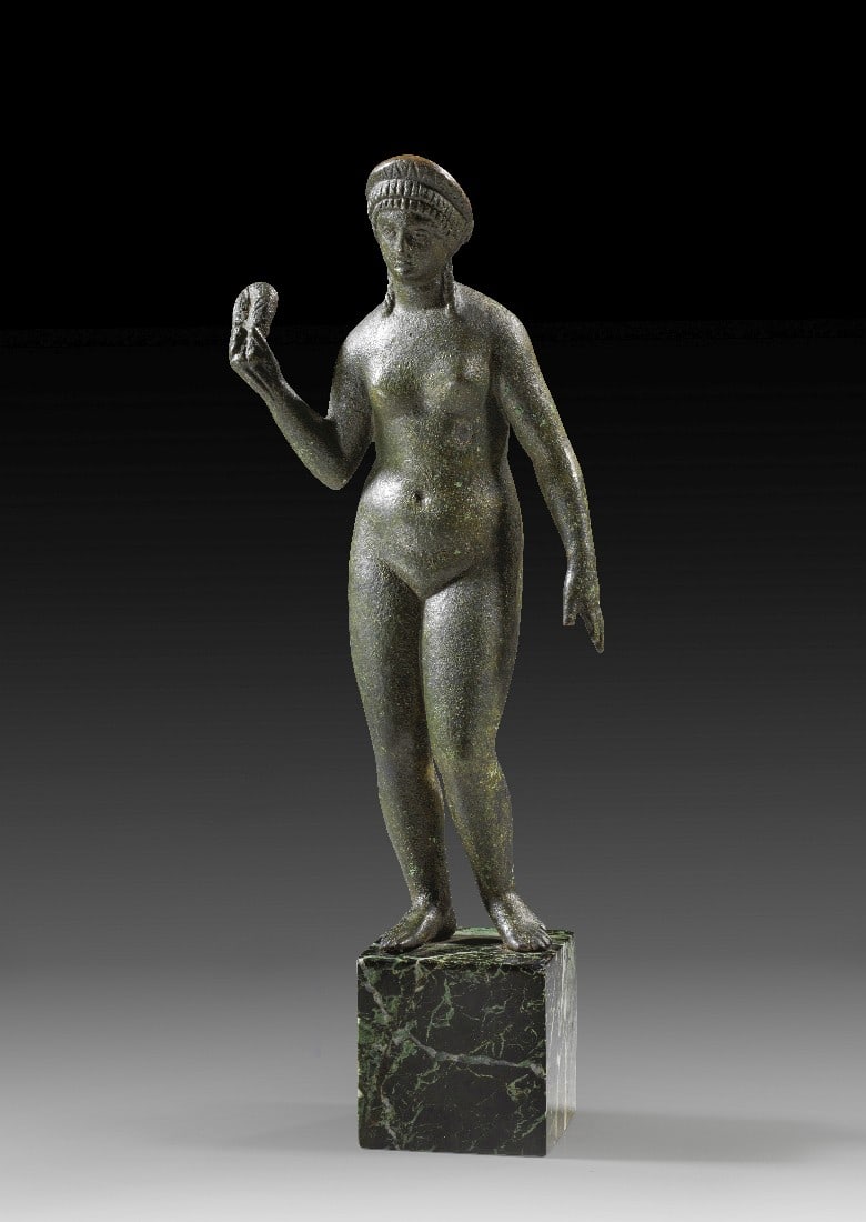 Isis-Aphrodite.: Isis-Aphrodite. Späthellenistisch - frühe Kaiserzeit, 1. Jh. v. Chr. - 1. Jh. n. Chr. H 20,5cm. Hohlguss. Statuette einer nackten Frau, das linke Bein als Spielbein leicht zurückgesetzt. Die