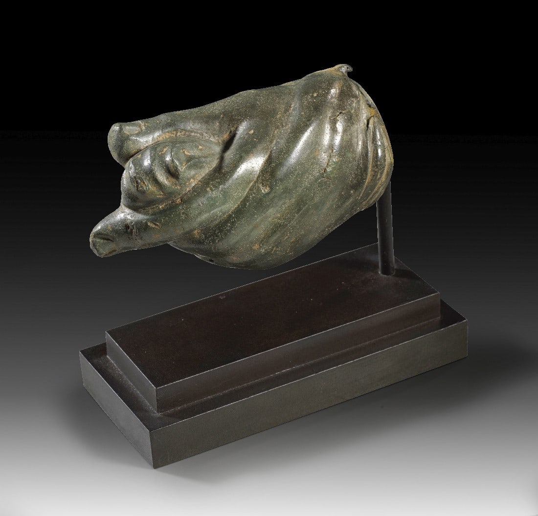 Hand einer römischen Gewandstatue.: Hand einer römischen Gewandstatue. Mittlere Kaiserzeit, 3. Jh. n. Chr. L 12,2cm. Hohlguss. Linke Hand eines Knaben, die einen Zipfel des Mantel zwischen Daumen und Zeigefinger hält und deren