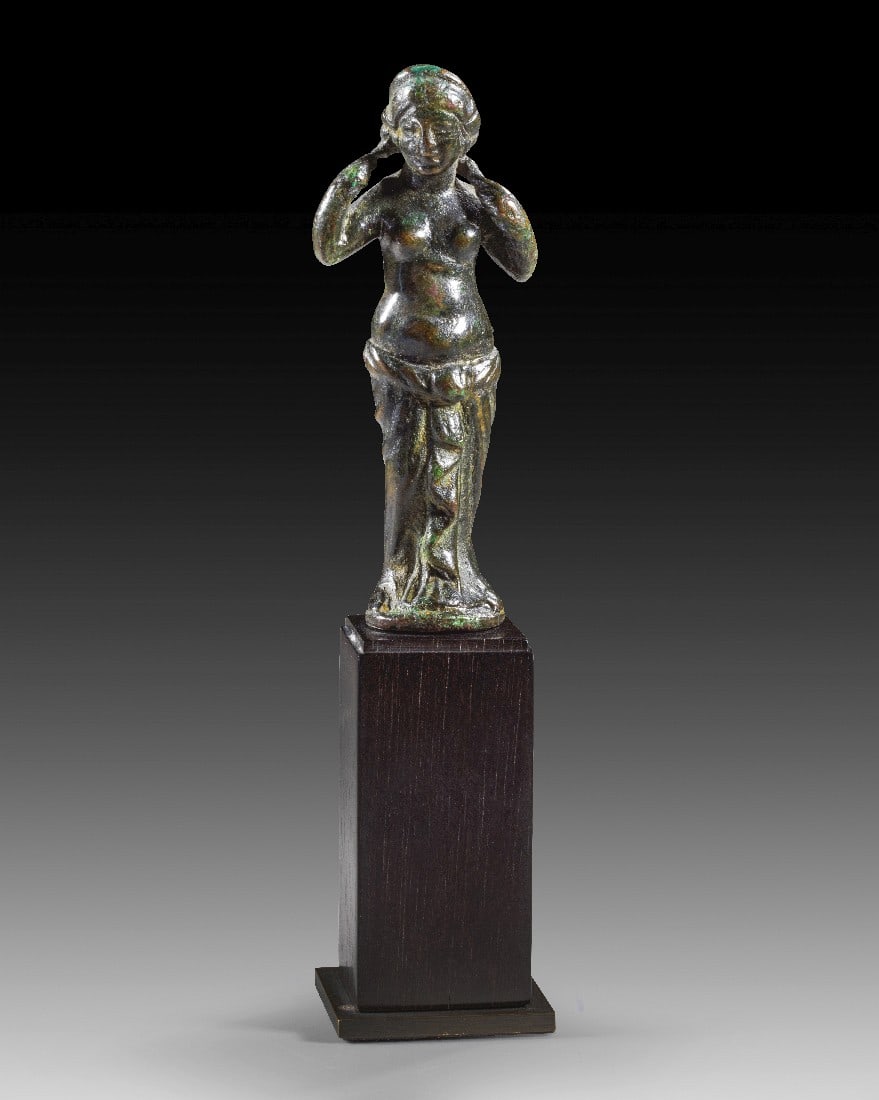 Venus Anadyomene.: Venus Anadyomene. Mittlere römische Kaiserzeit, 2. Hälfte 2. Jh. n. Chr. H 7,1cm und mit Sockel 12cm. Vollguss. Aphrodite wird hier in dem Moment gezeigt, nachdem sie dem Meer entstiegen ist und