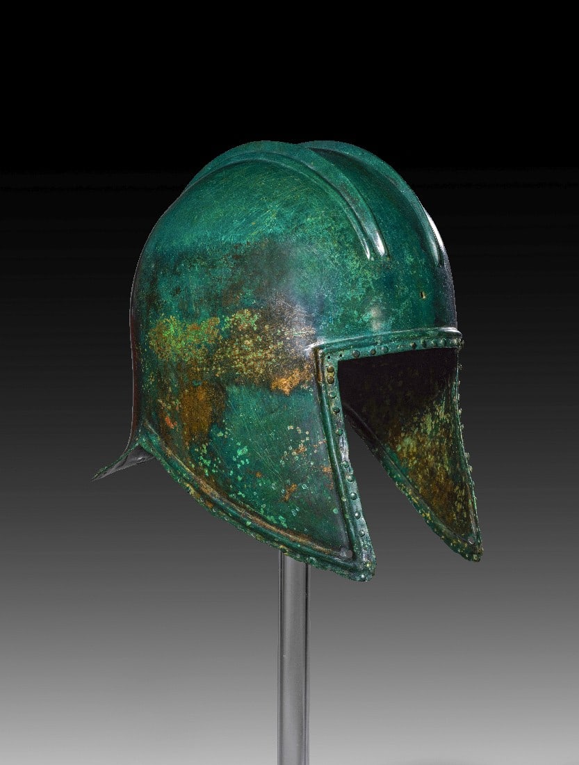 Illyrischer Helm.: Illyrischer Helm. Griechisch, 7. - 5. Jh. v. Chr. H 26cm. Bronze. Auf der runden Kalotte zwei Doppelgrate für den Helmbusch, der an der Vorder- und Hinterseite an Löchern befestigt war. Am Rand des