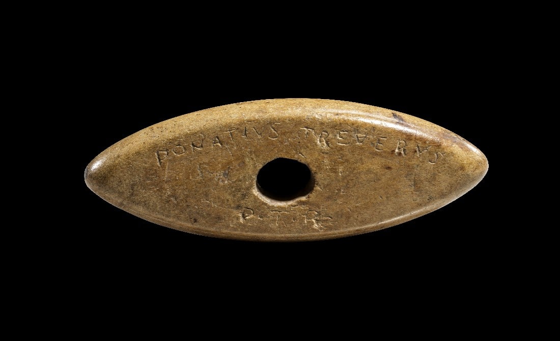 Parierstab eines römischen Schwertes.: Parierstab eines römischen Schwertes. 4. Jh. n. Chr. L 7,6cm. Hellbraunes Bein. Auf der einen Seite "DONATIVS TREVERVS / P·T·R", auf der anderen "PALCVM / VERIS". Kleine Absplitterungen seitlich