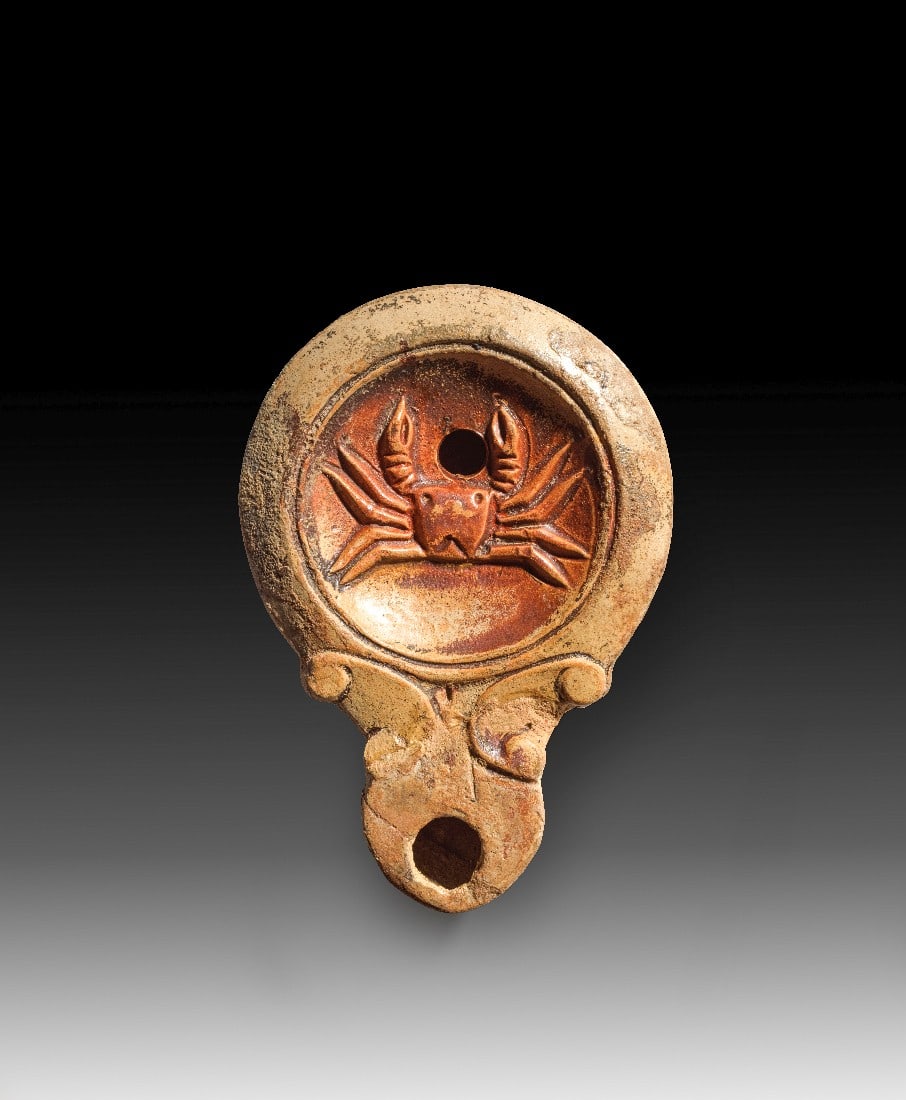 Römische Tonlampe mit Krabbe.: Römische Tonlampe mit Krabbe. Kaiserzeitlich, 1. Jh. n. Chr. L 11,2cm. Loeschcke IV. Beiger Ton mit rotbraunem Überzug. Auf der Unterseite die Töpfersignatur L MADIEC. Kleiner Teil der Schnauze