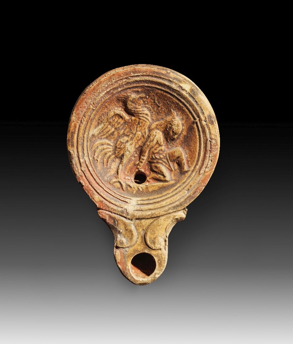 Römische Tonlampe mit Gladiator.: Römische Tonlampe mit Gladiator. Kaiserzeitlich, 1. - 2. Jh. n. Chr. L 10,5cm. Typus Loeschcke IV. Hellbeiger Ton mit rotbraunem Überzug. Auf dem Spiegel ein Gladiator in den Fängen eines Adlers.